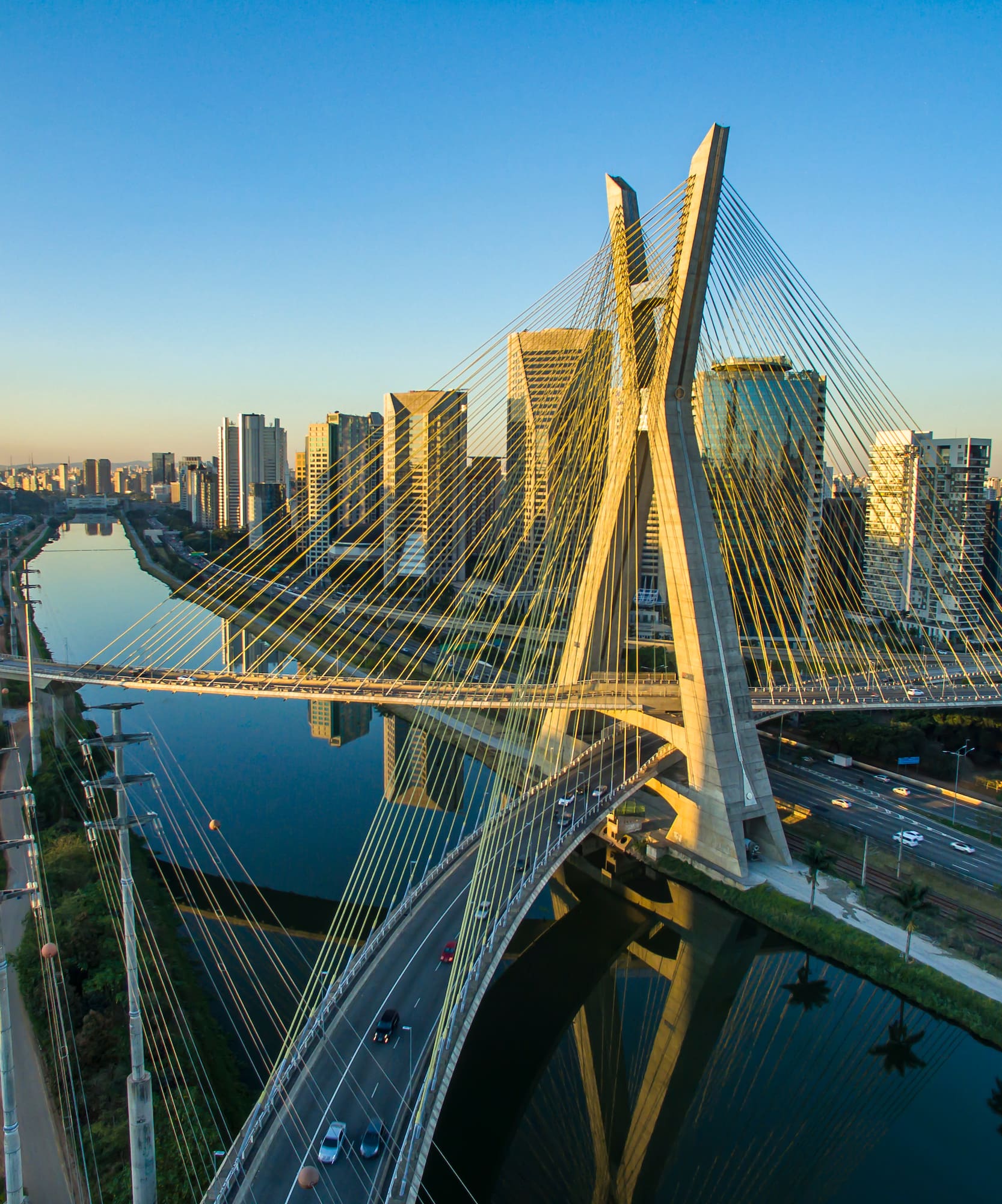 a bridge over a river with a city in the background
