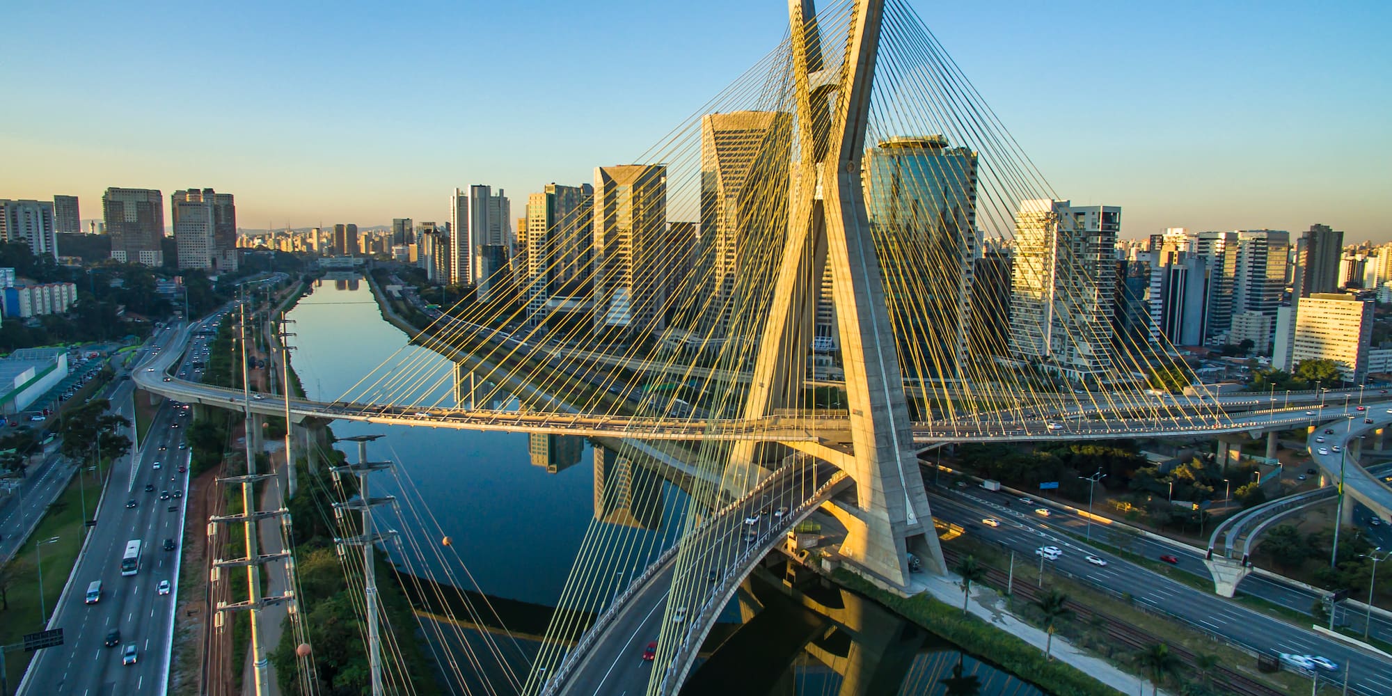 a bridge over a river with a city in the background