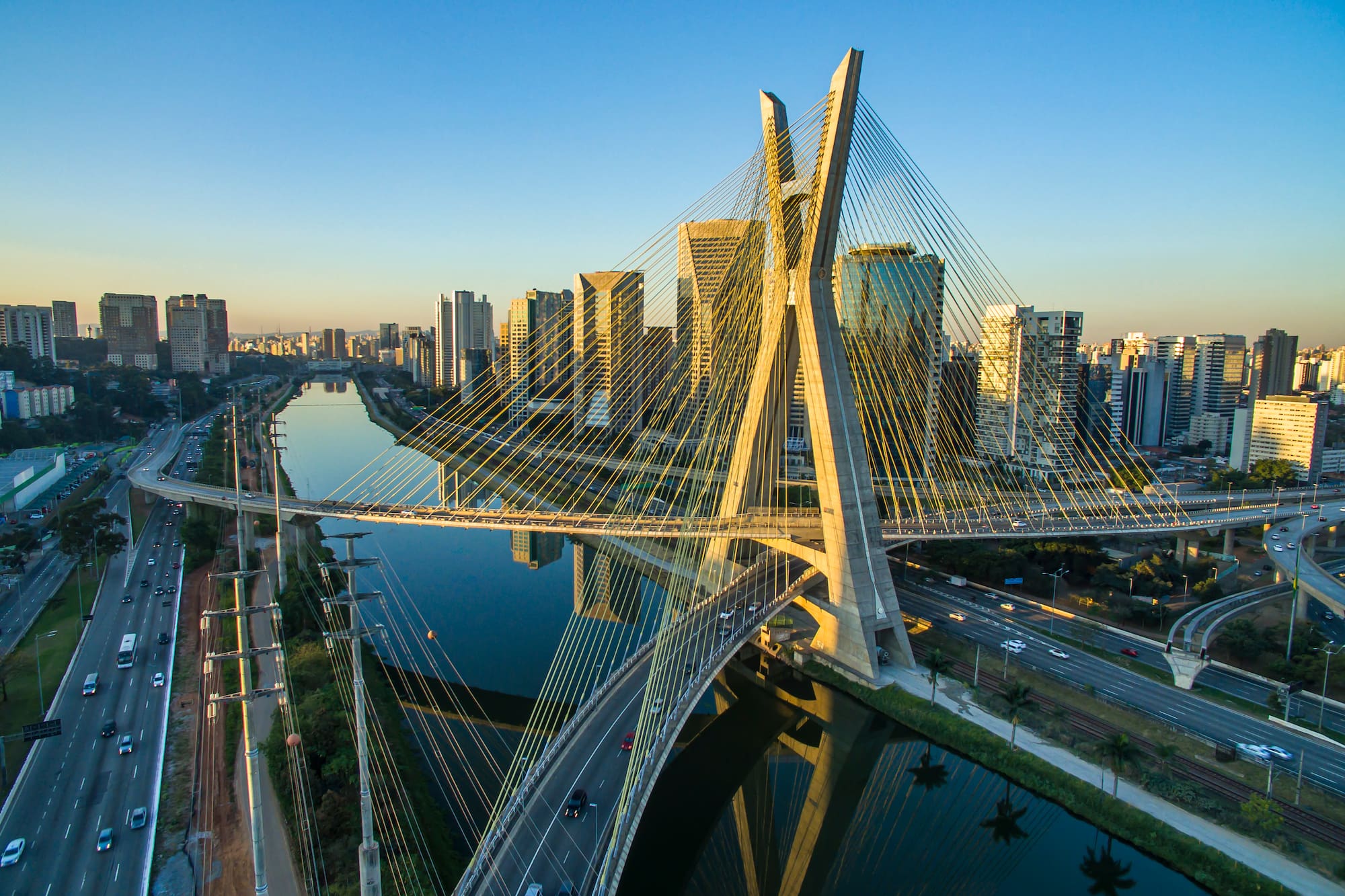 a bridge over a river with a city in the background