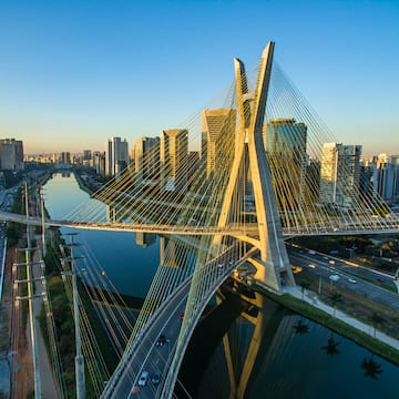 a bridge over a river with a city in the background