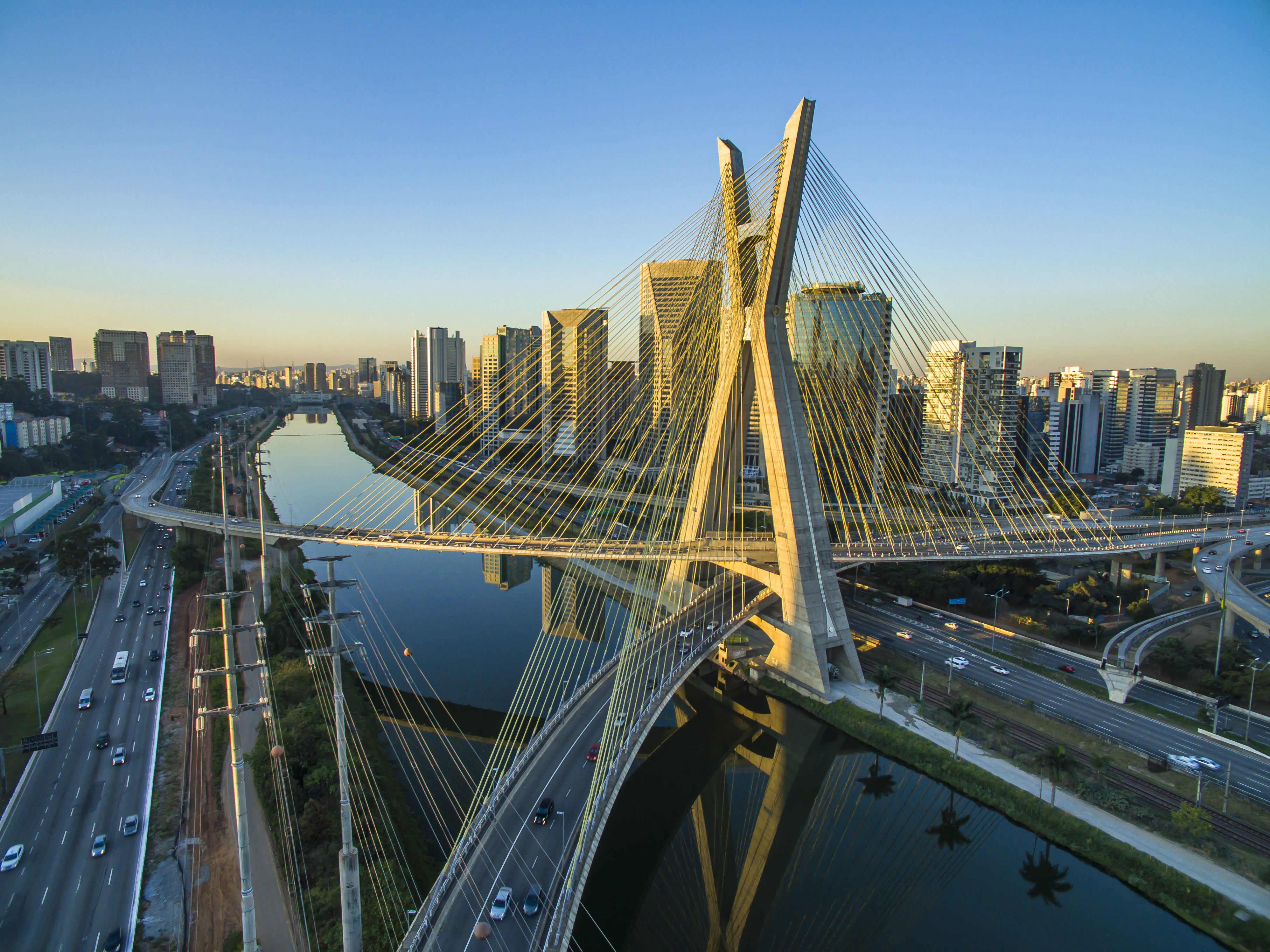 a bridge over a river with a city in the background
