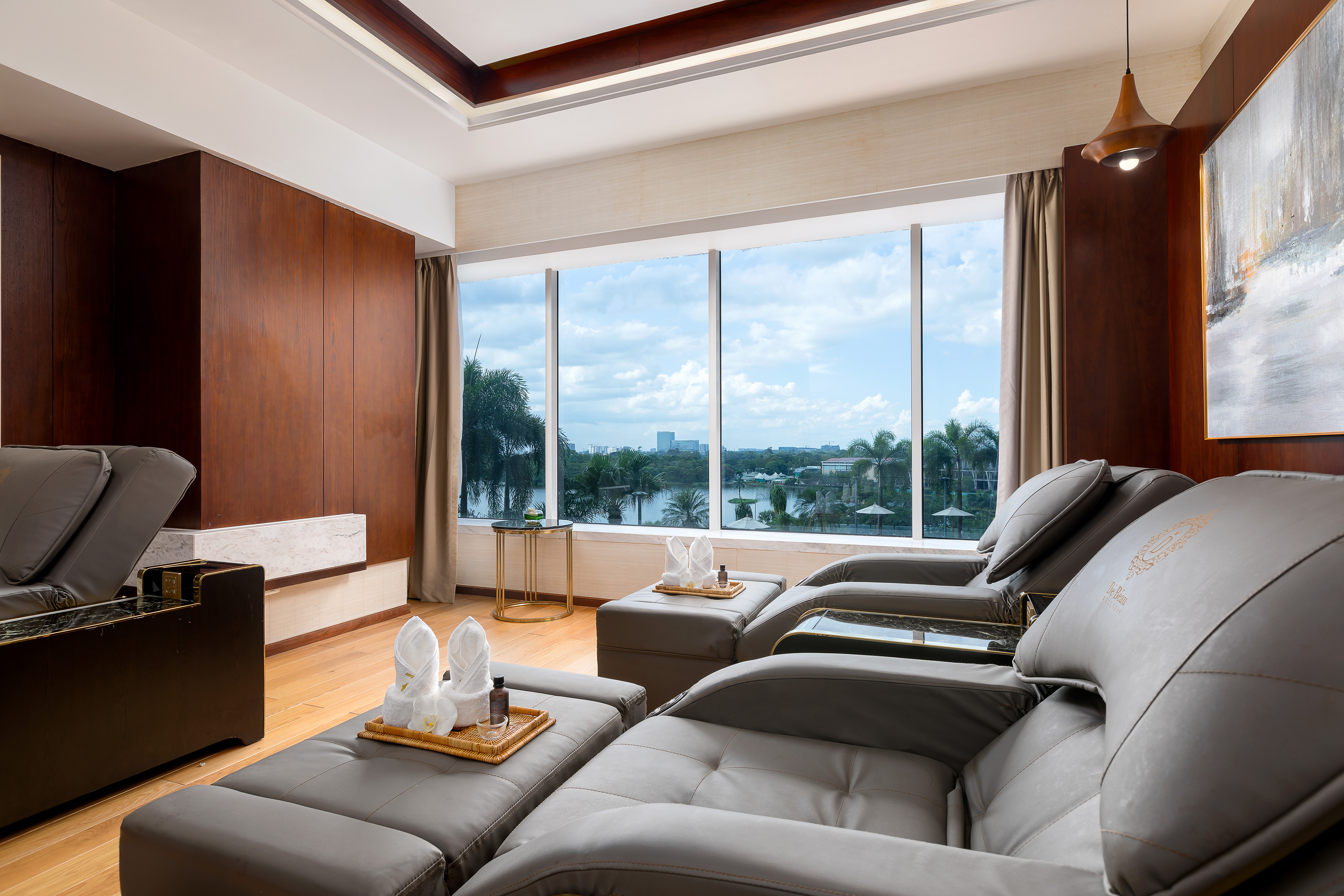 Modern spa relaxation room with massage recliners and panoramic lake view.