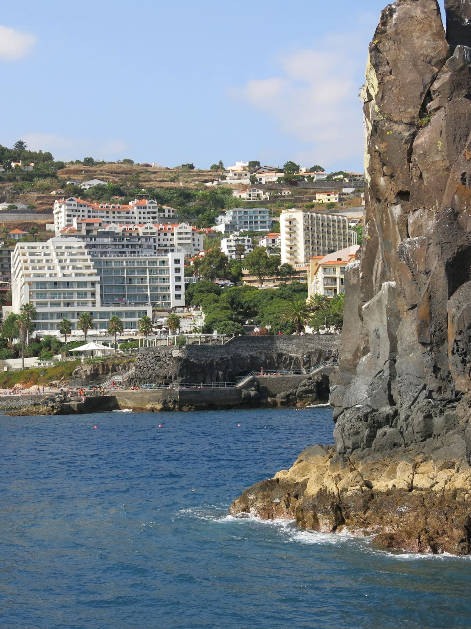 a rocky cliff next to water