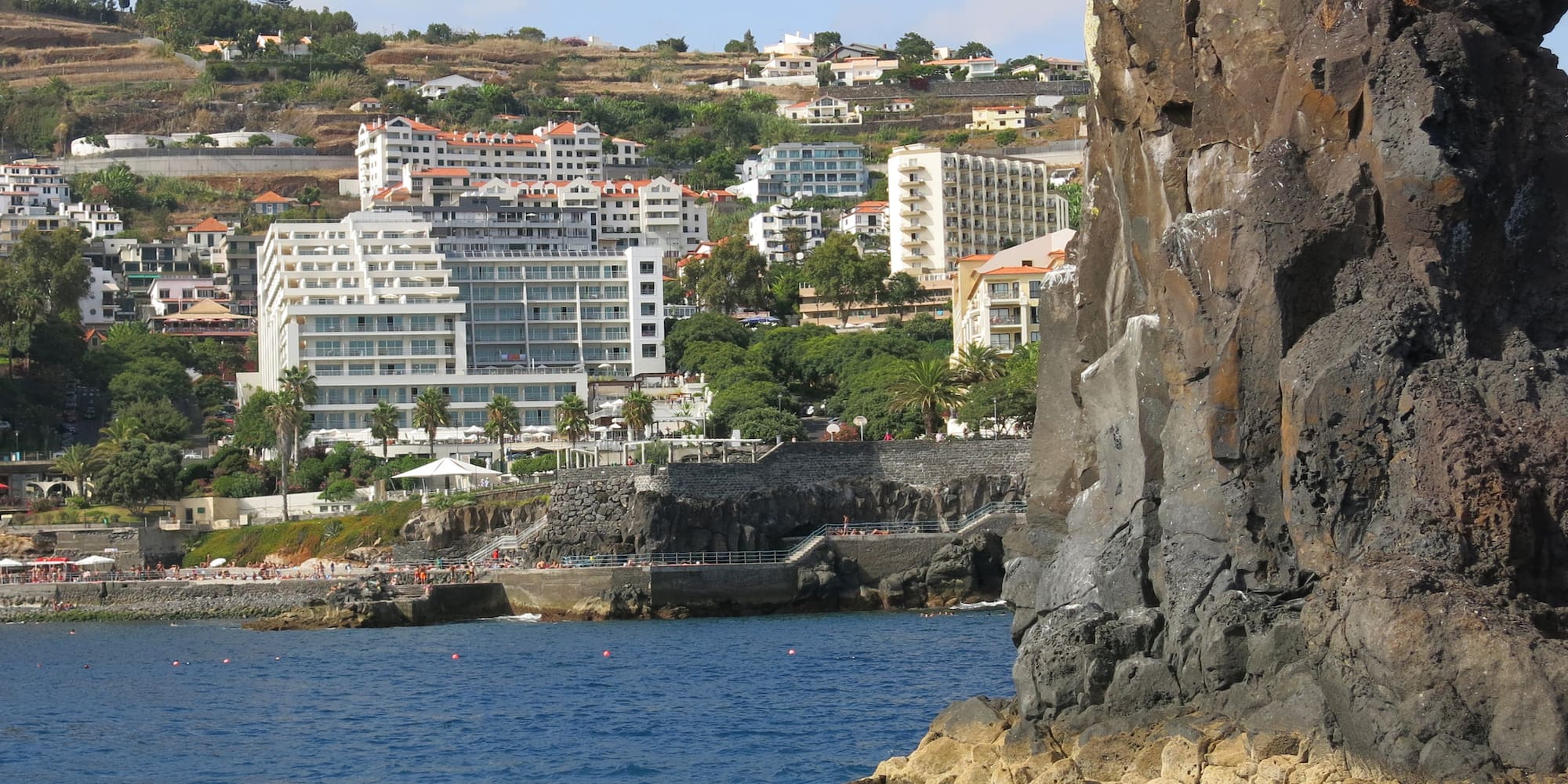 a rocky cliff next to water