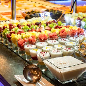 a table full of fruit and yogurt desserts