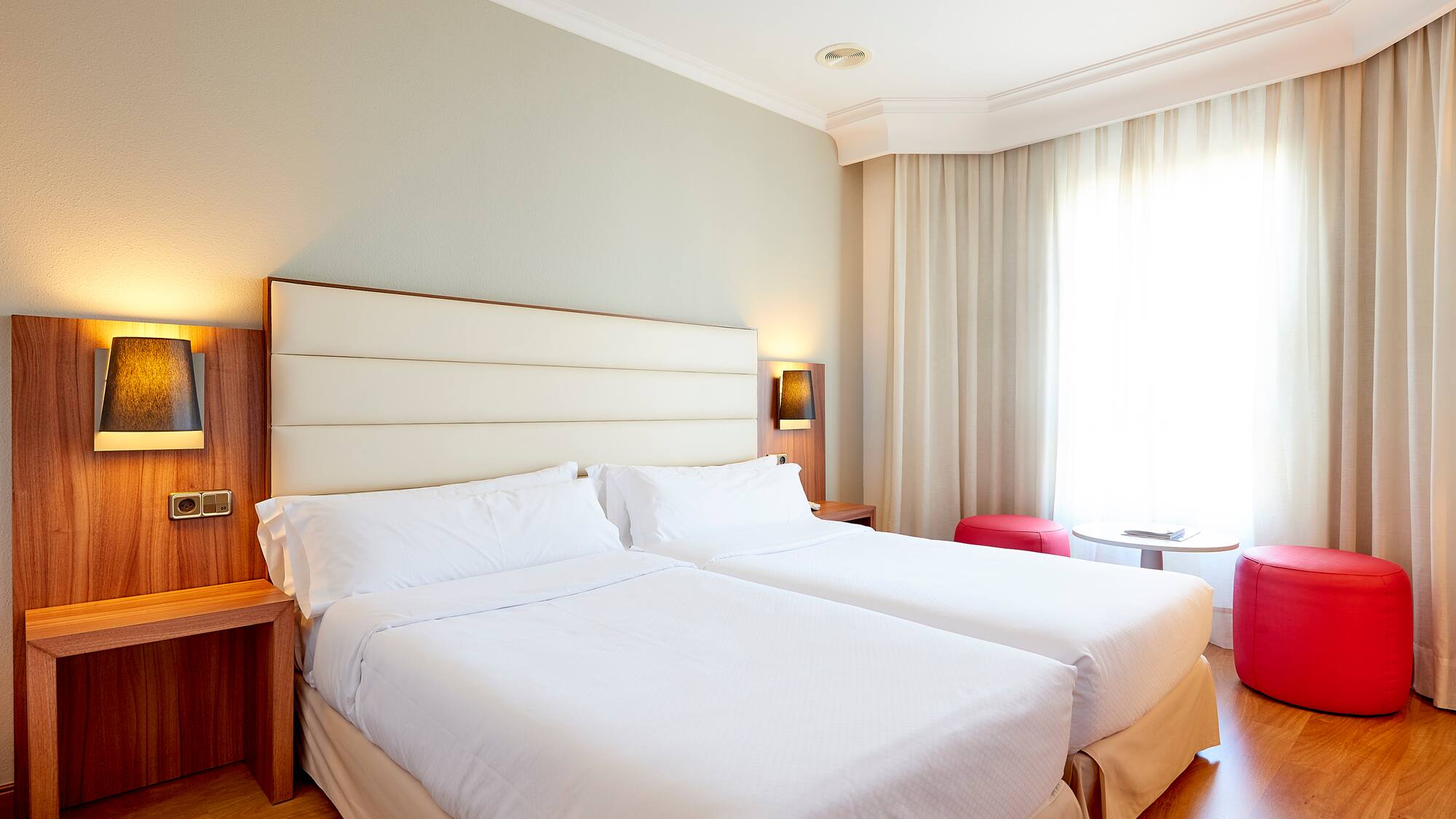 a room with two beds and a window