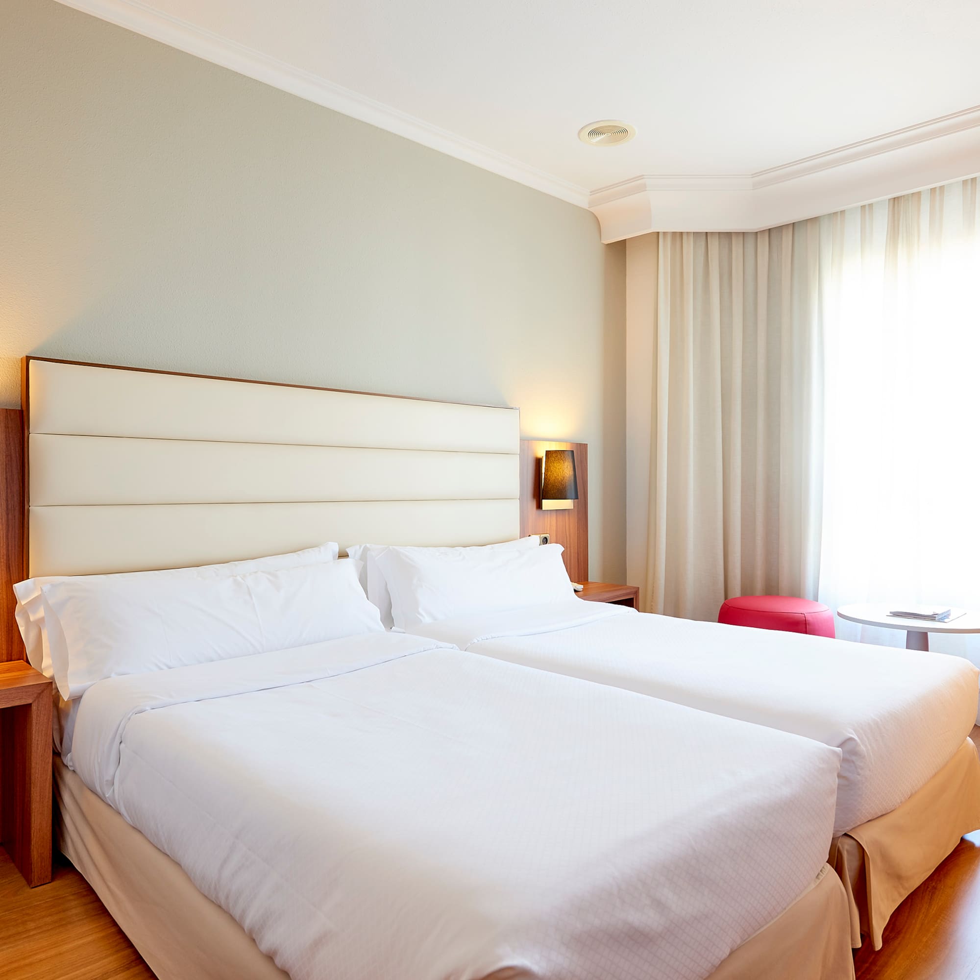 a room with two beds and a window