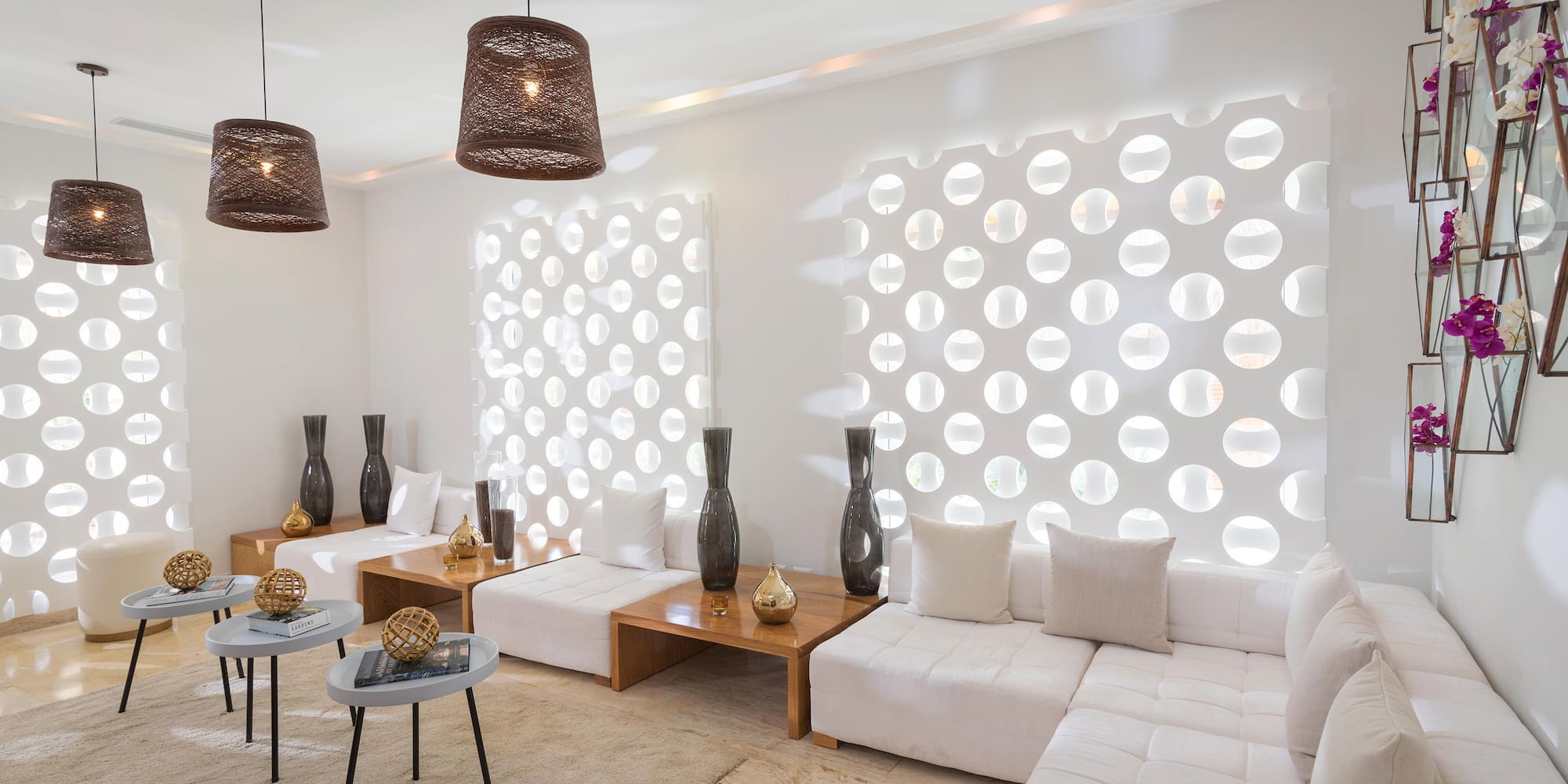 a room with white furniture and brown lamps