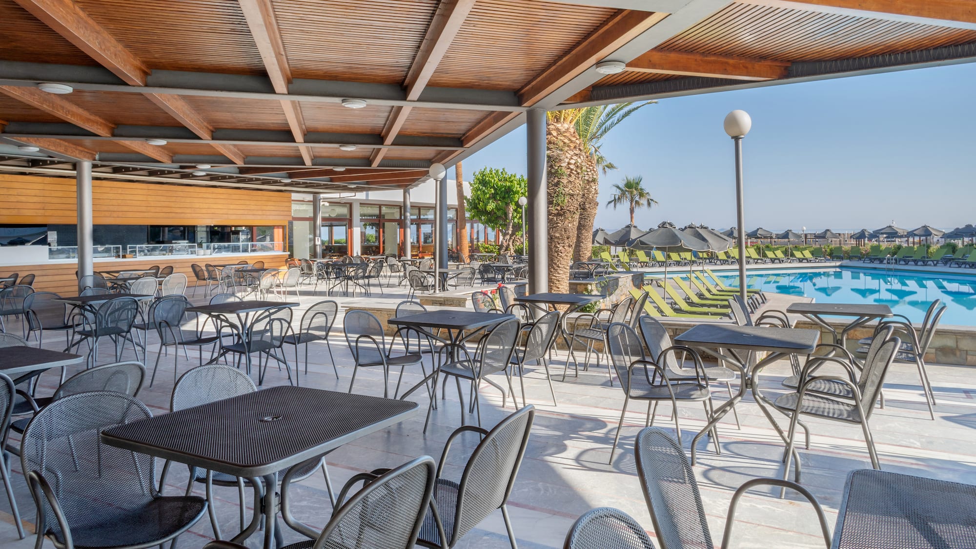 a patio with tables and chairs and a pool