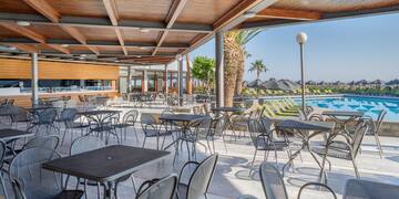 a patio with tables and chairs and a pool