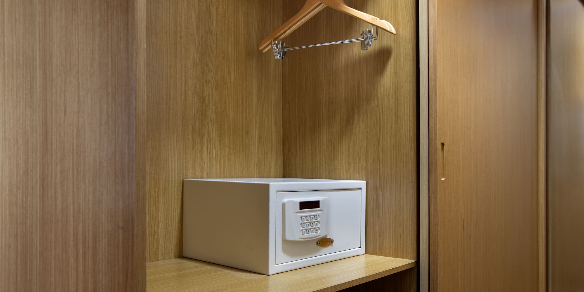 a white safe on a wooden shelf