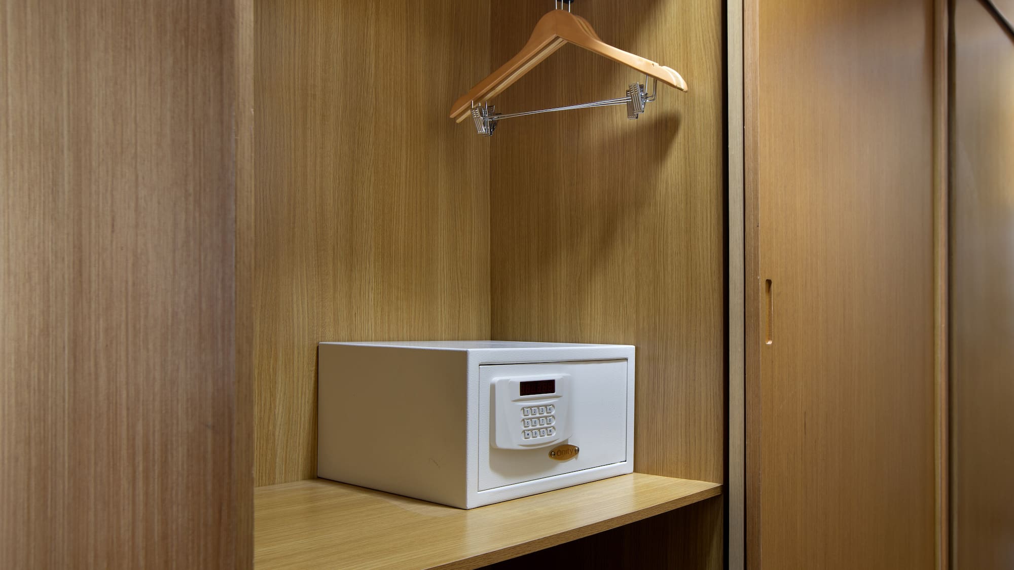a white safe on a wooden shelf