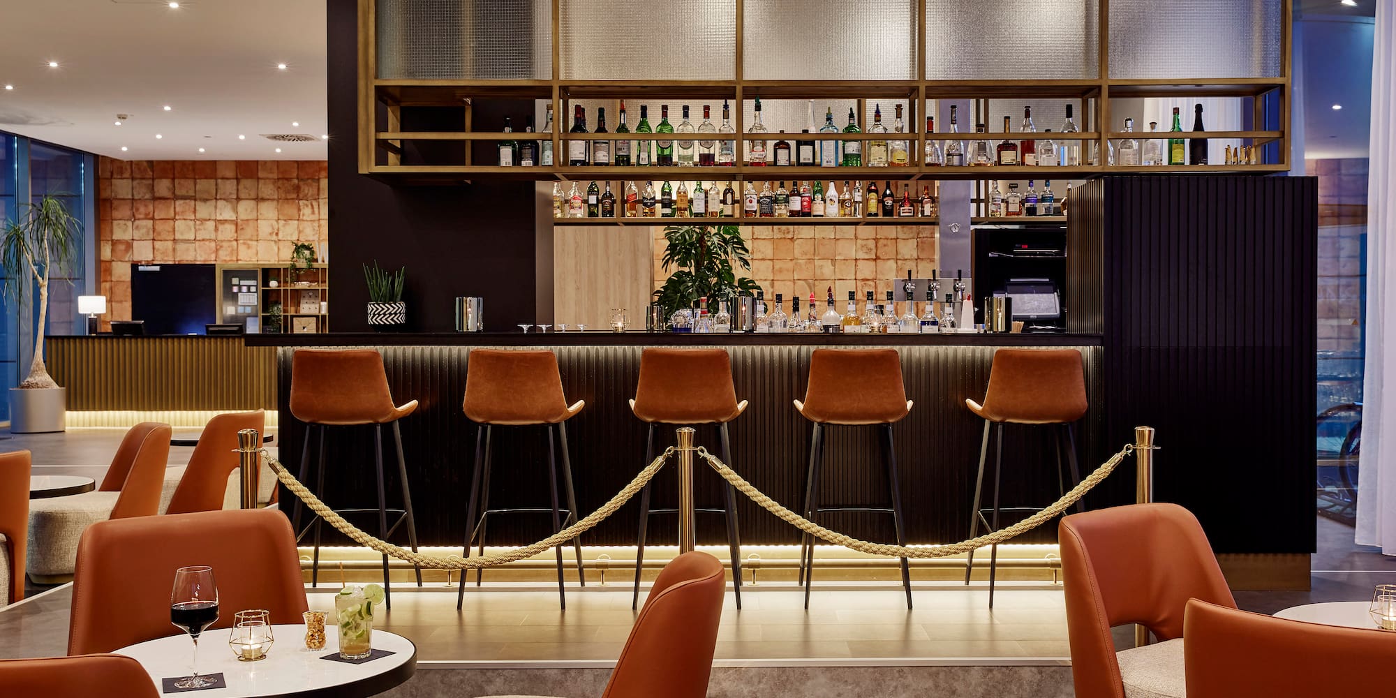 a bar with chairs and a bar with a rope around it