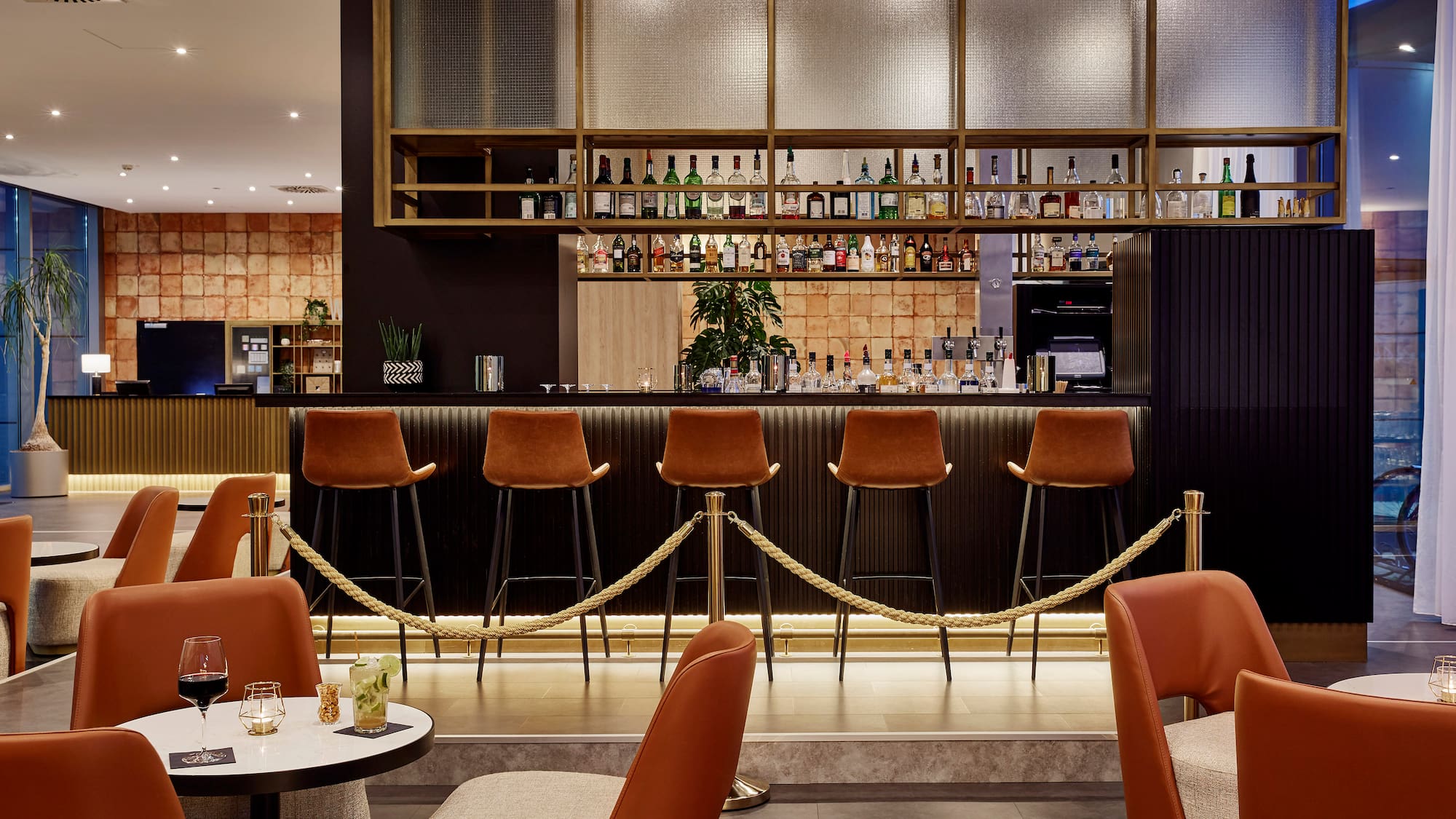 a bar with chairs and a bar with a rope around it