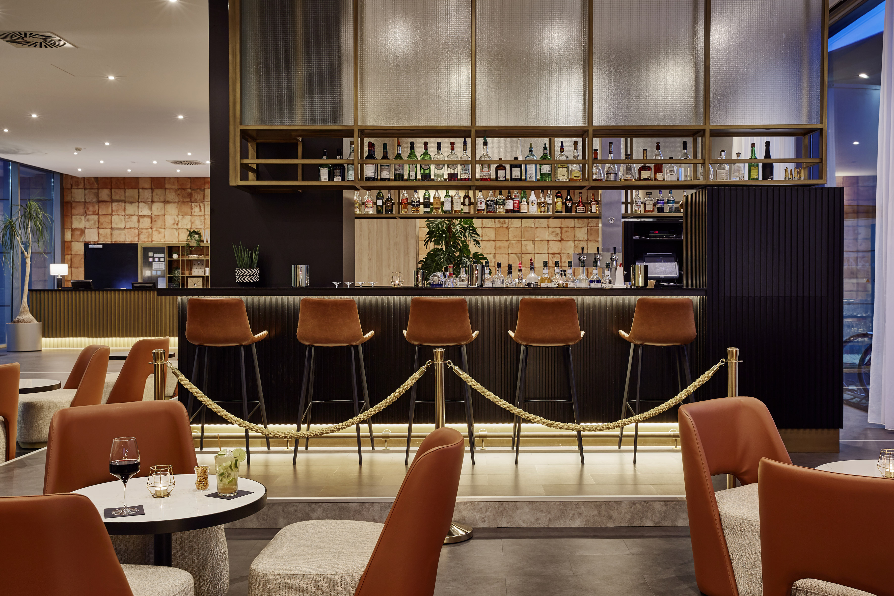 a bar with chairs and a bar with a rope around it