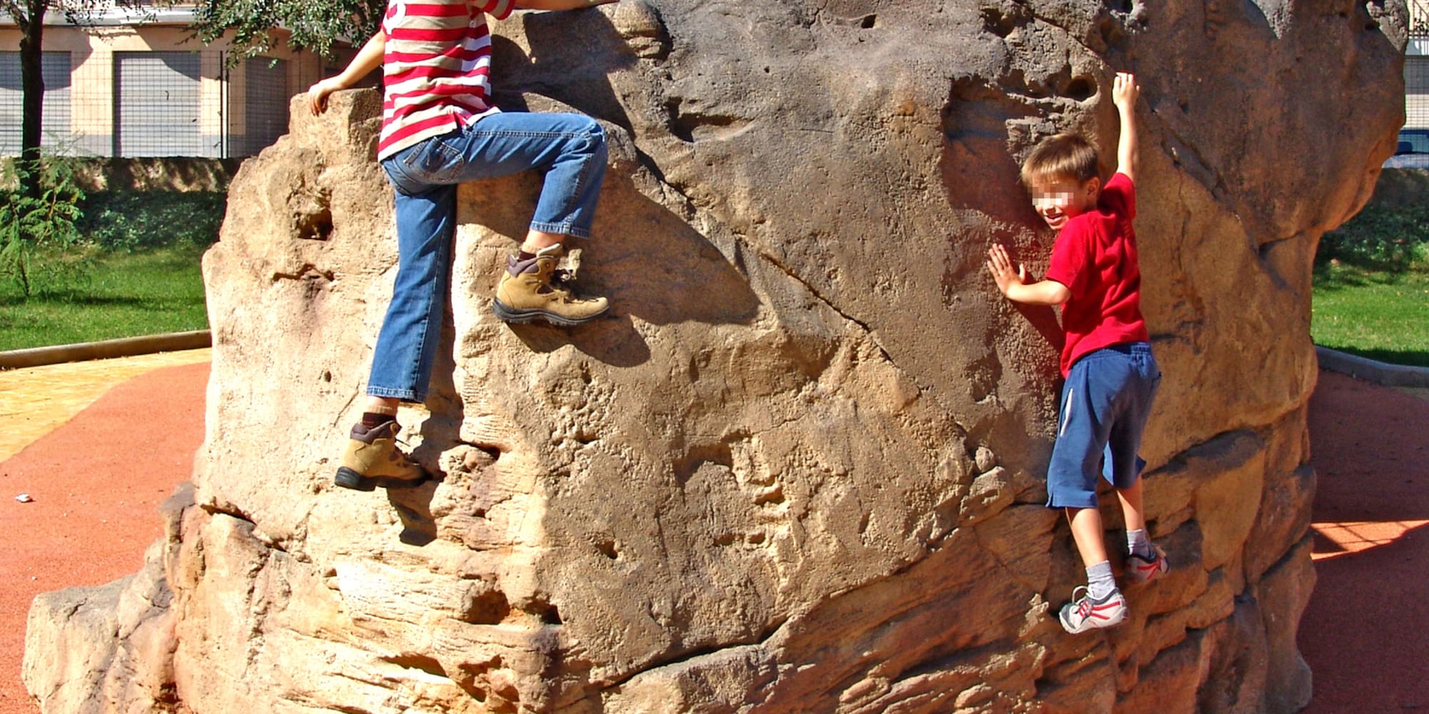 a pair of kids climbing a rock