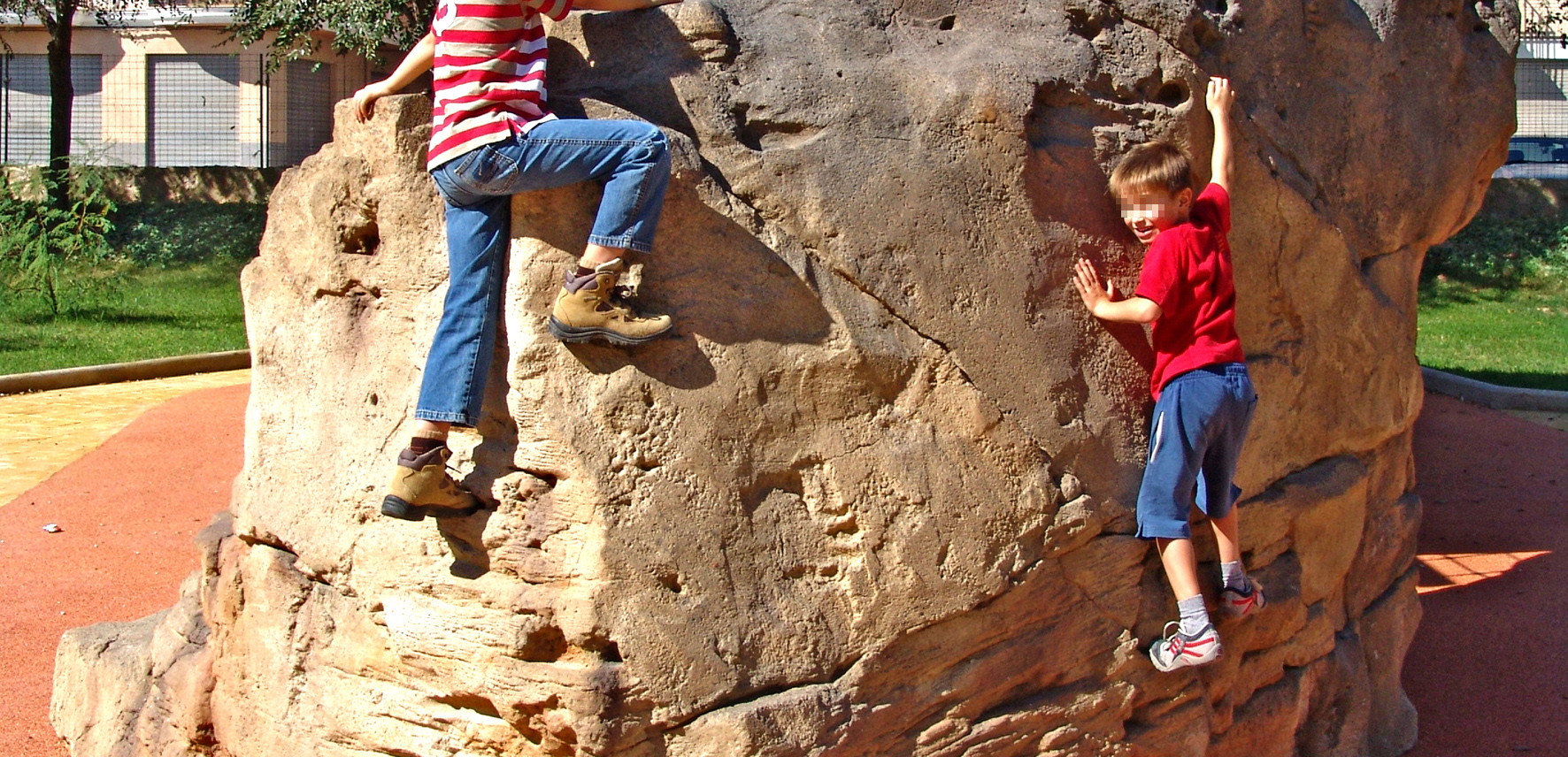 a pair of kids climbing a rock