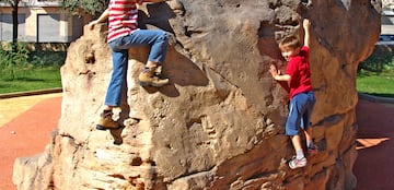 a pair of kids climbing a rock