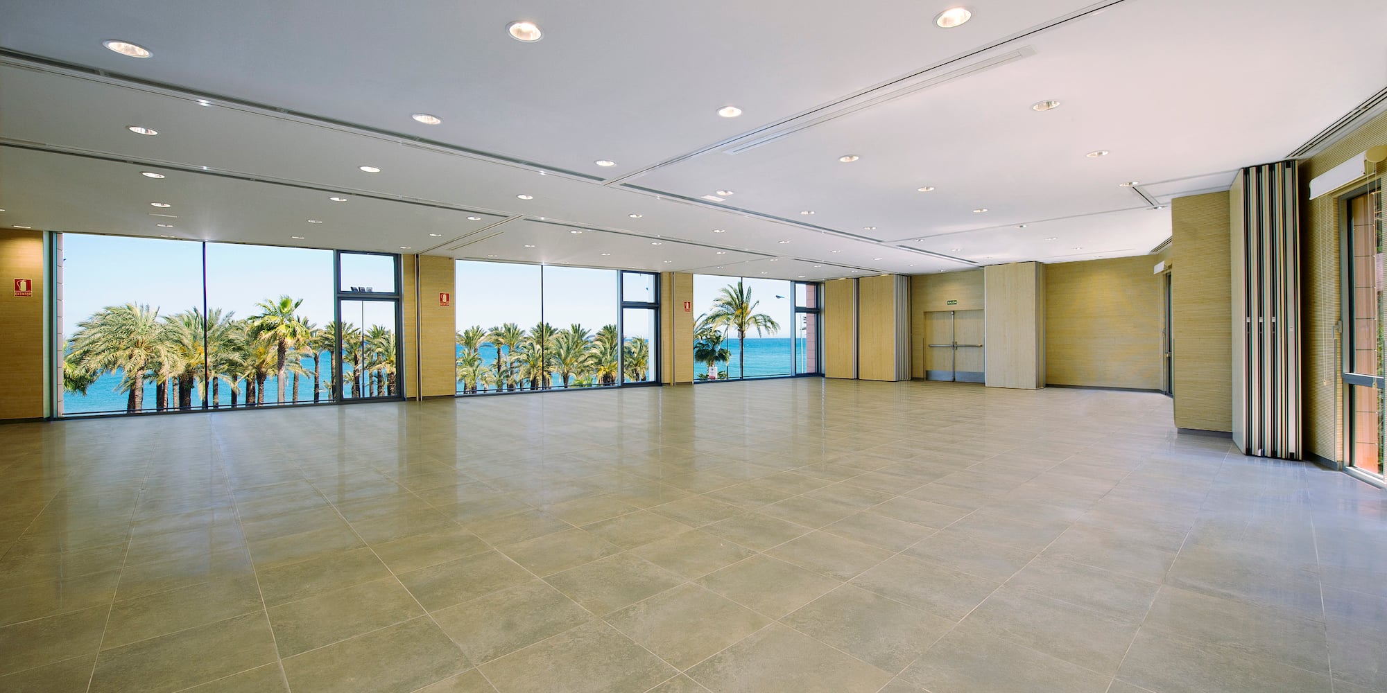 a large room with windows and trees in the background