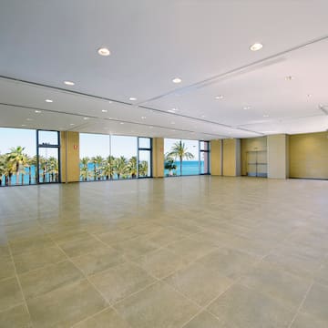 a large room with windows and trees in the background