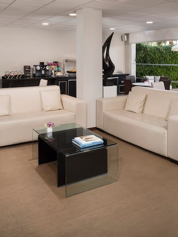 a room with white couches and a glass coffee table