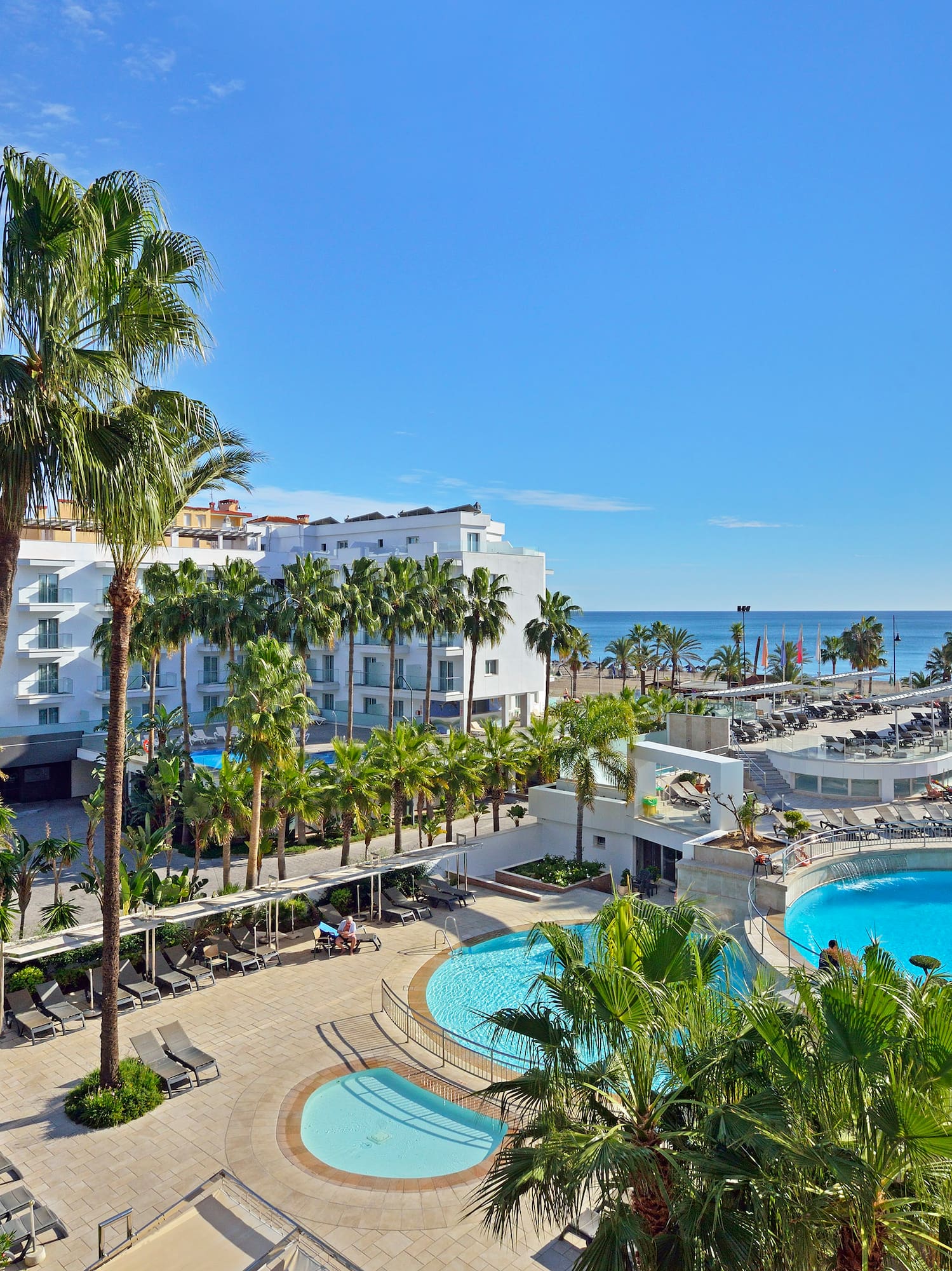 a swimming pool and palm trees next to a building