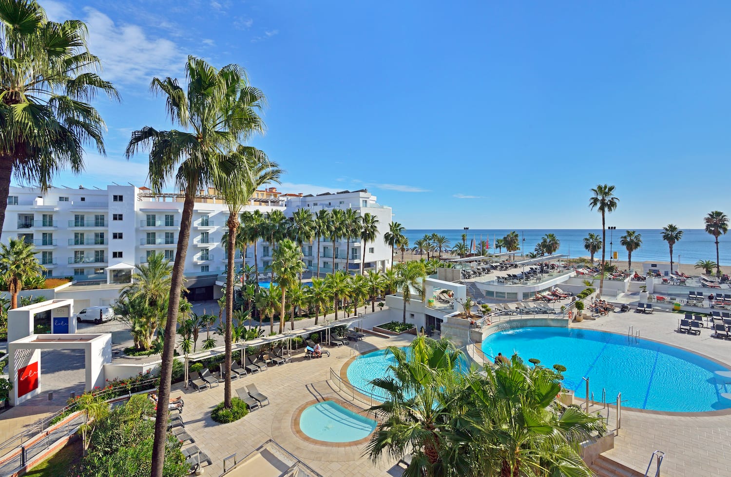 a swimming pool and palm trees next to a building