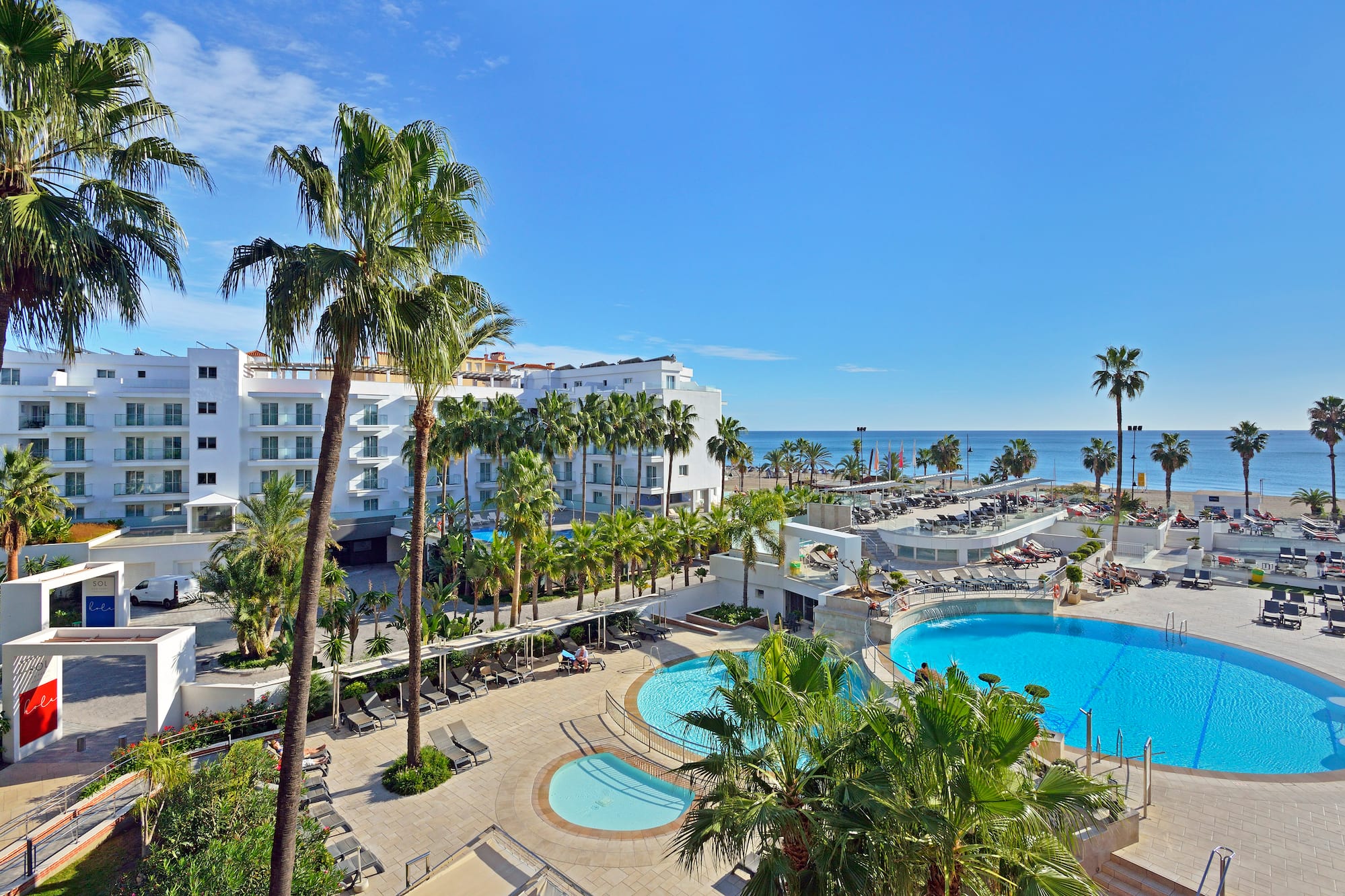 a swimming pool and palm trees next to a building