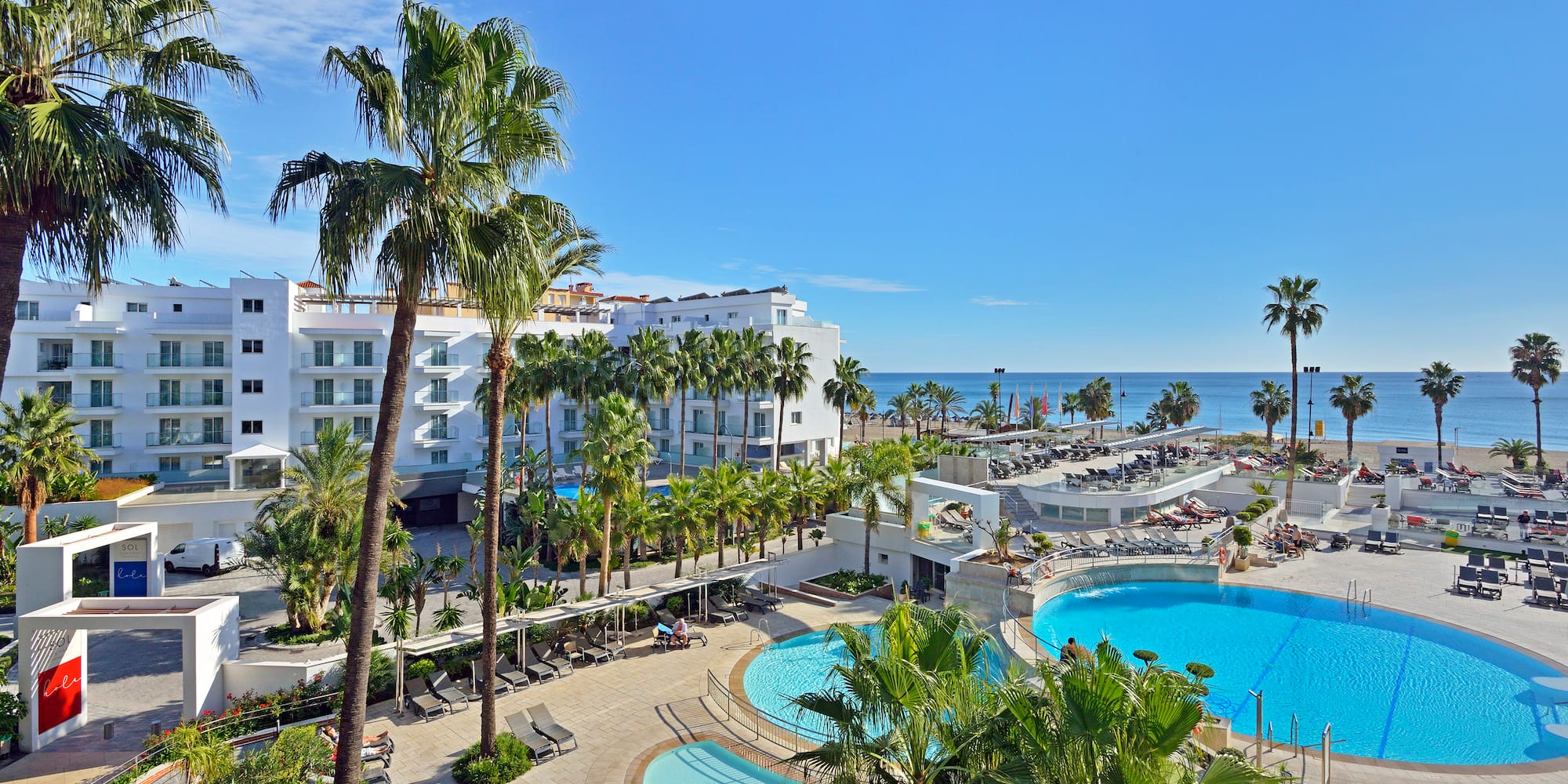 a swimming pool and palm trees next to a building
