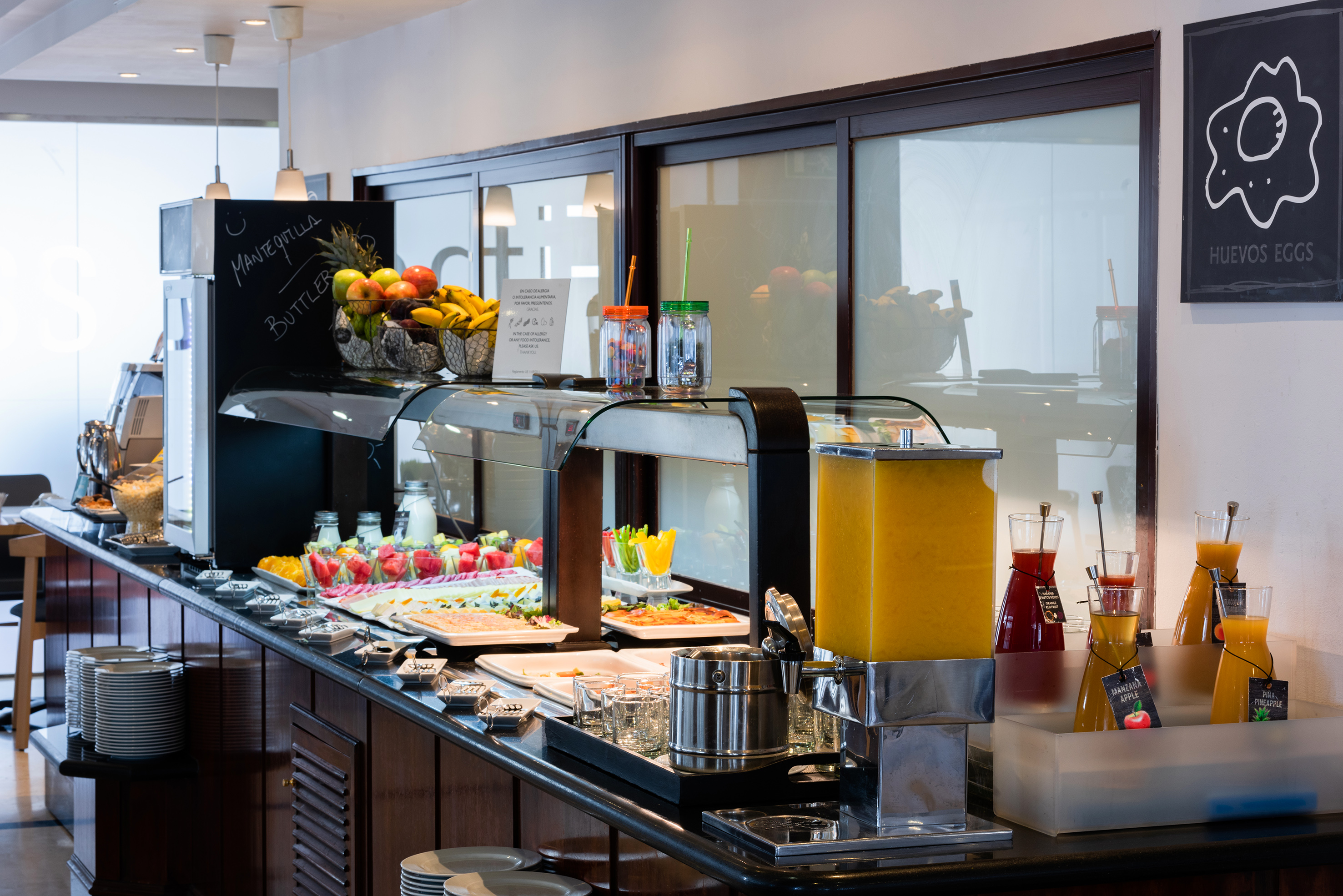 Hotel breakfast buffet with fresh fruit, orange juice, and various hot dishes.