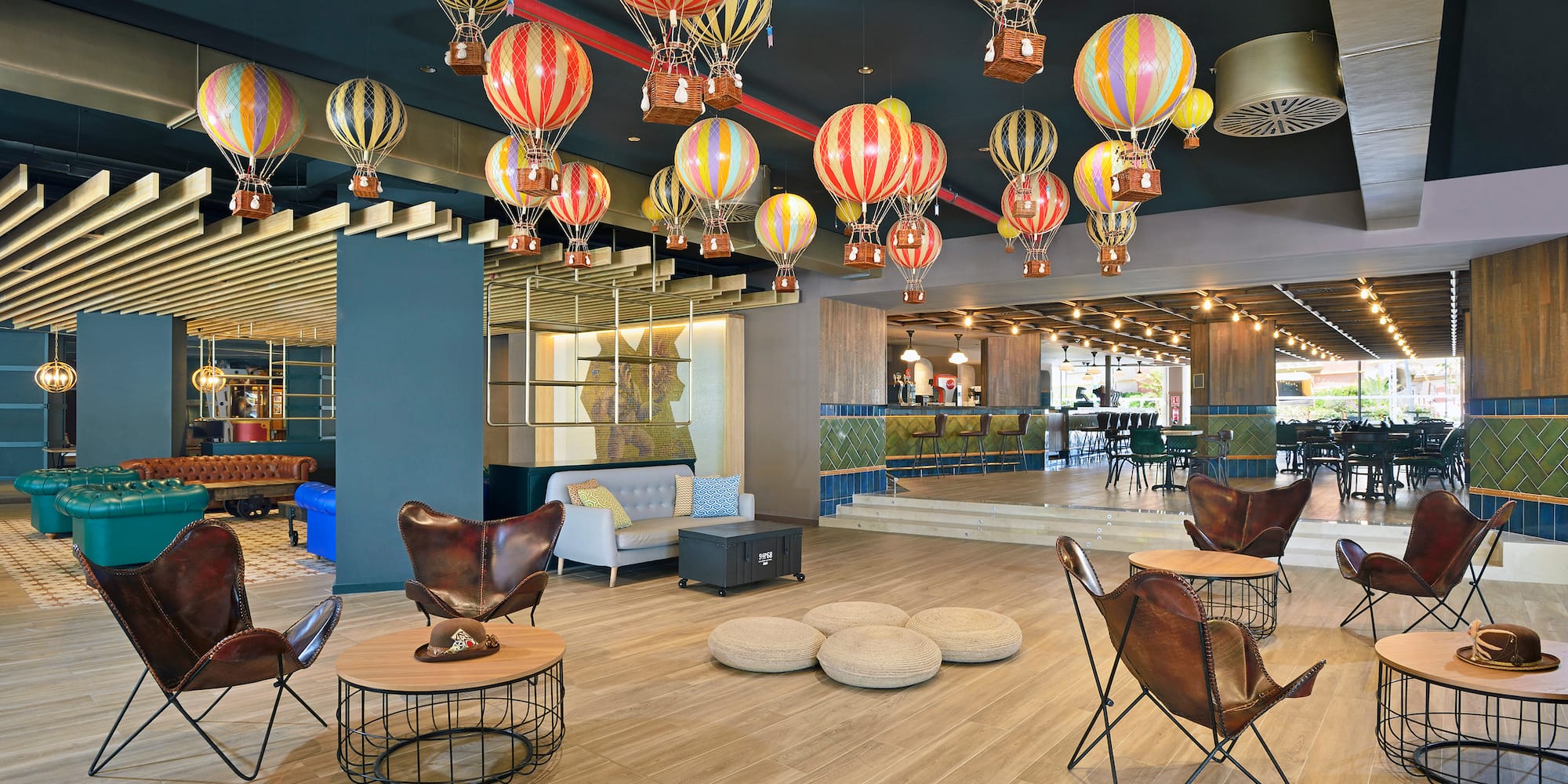 a room with a large group of hot air balloons from the ceiling