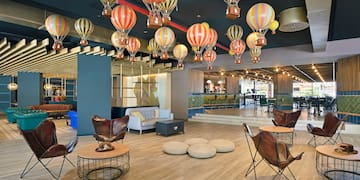 a room with a large group of hot air balloons from the ceiling