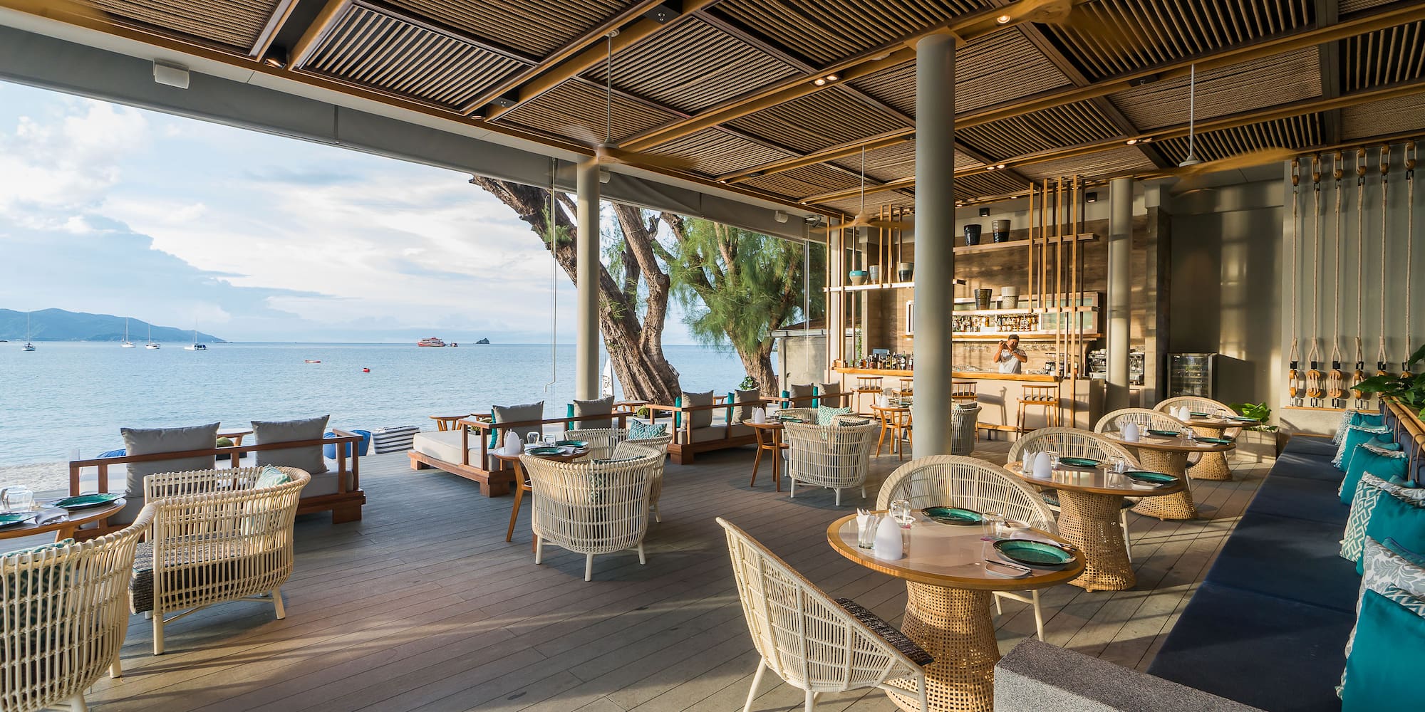 a restaurant with tables and chairs on a deck overlooking a body of water