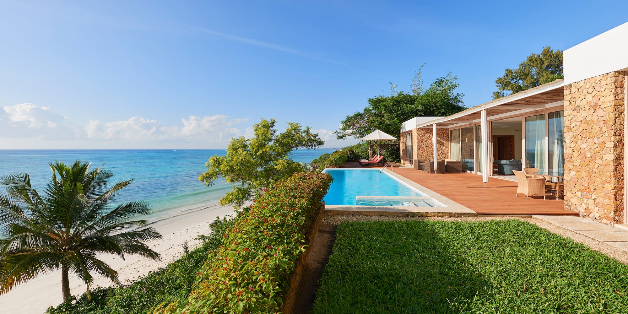 a pool and a house with a beach and trees