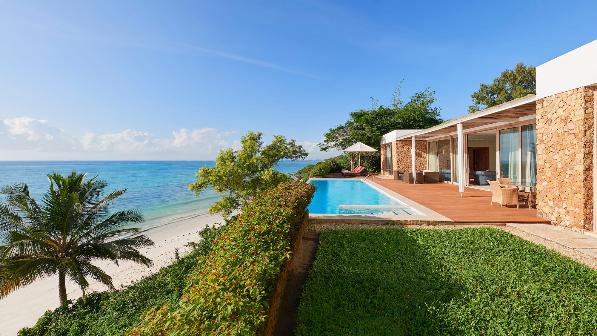 a pool and a house with a beach and trees
