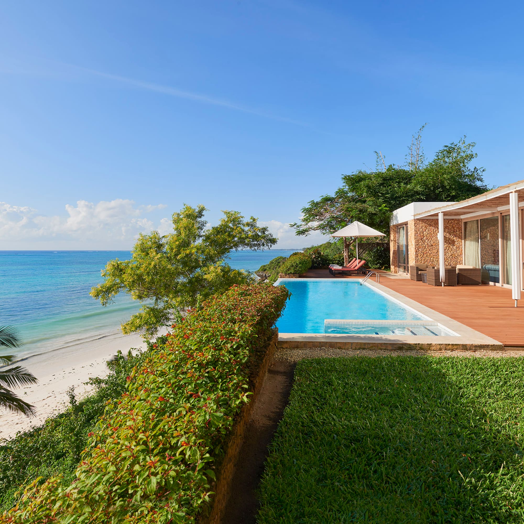 a pool and a house with a beach and trees