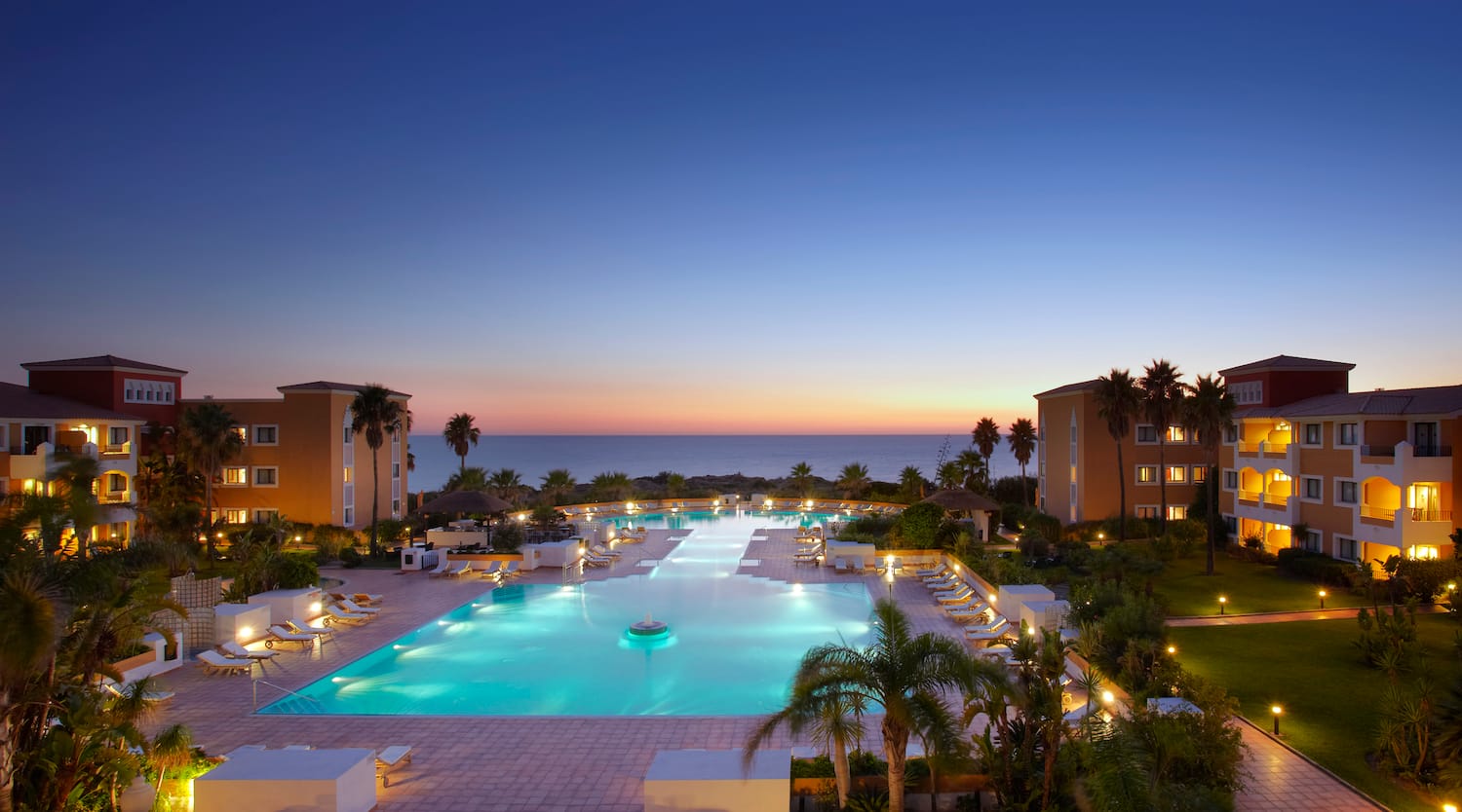 a pool with chairs and a large body of water