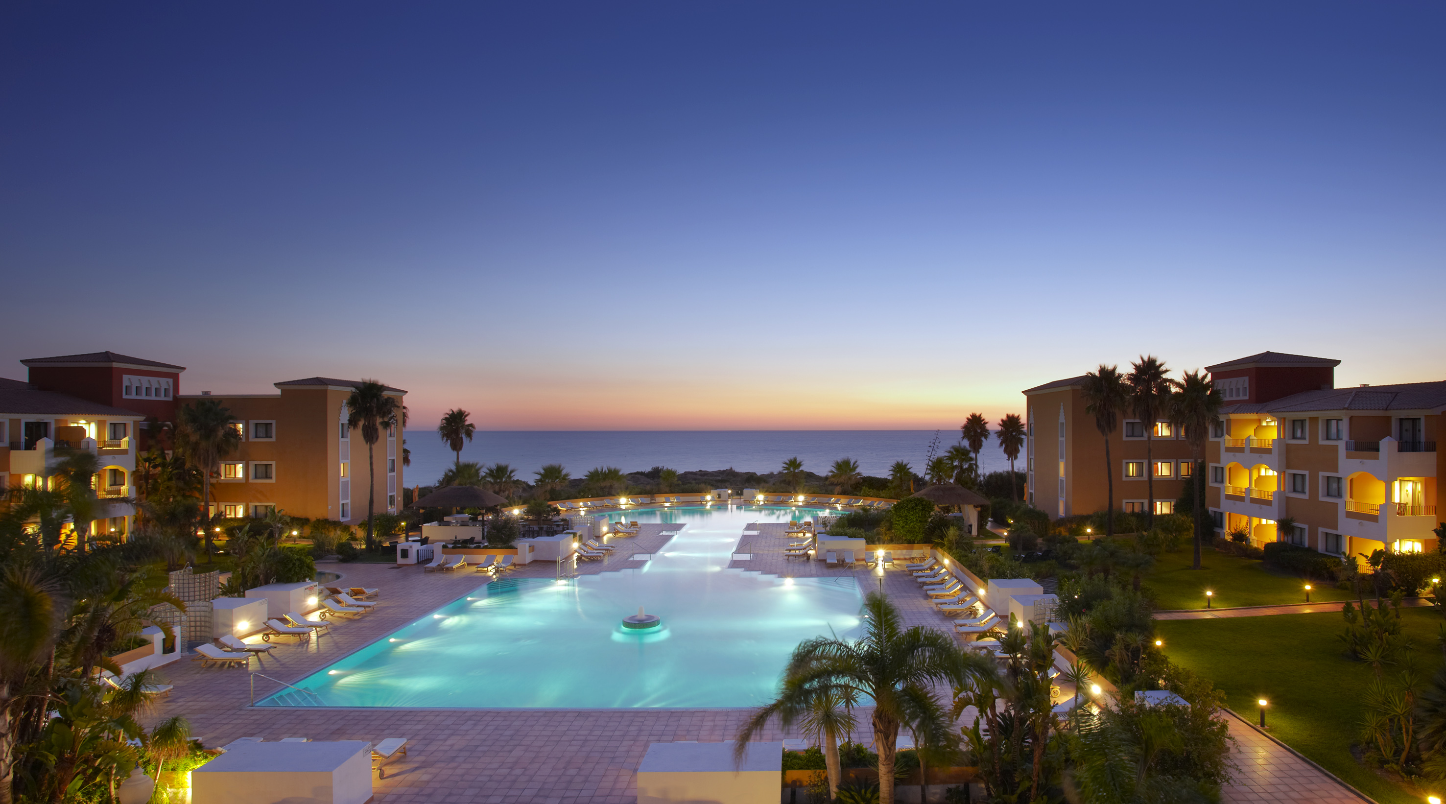 a pool with chairs and a large body of water