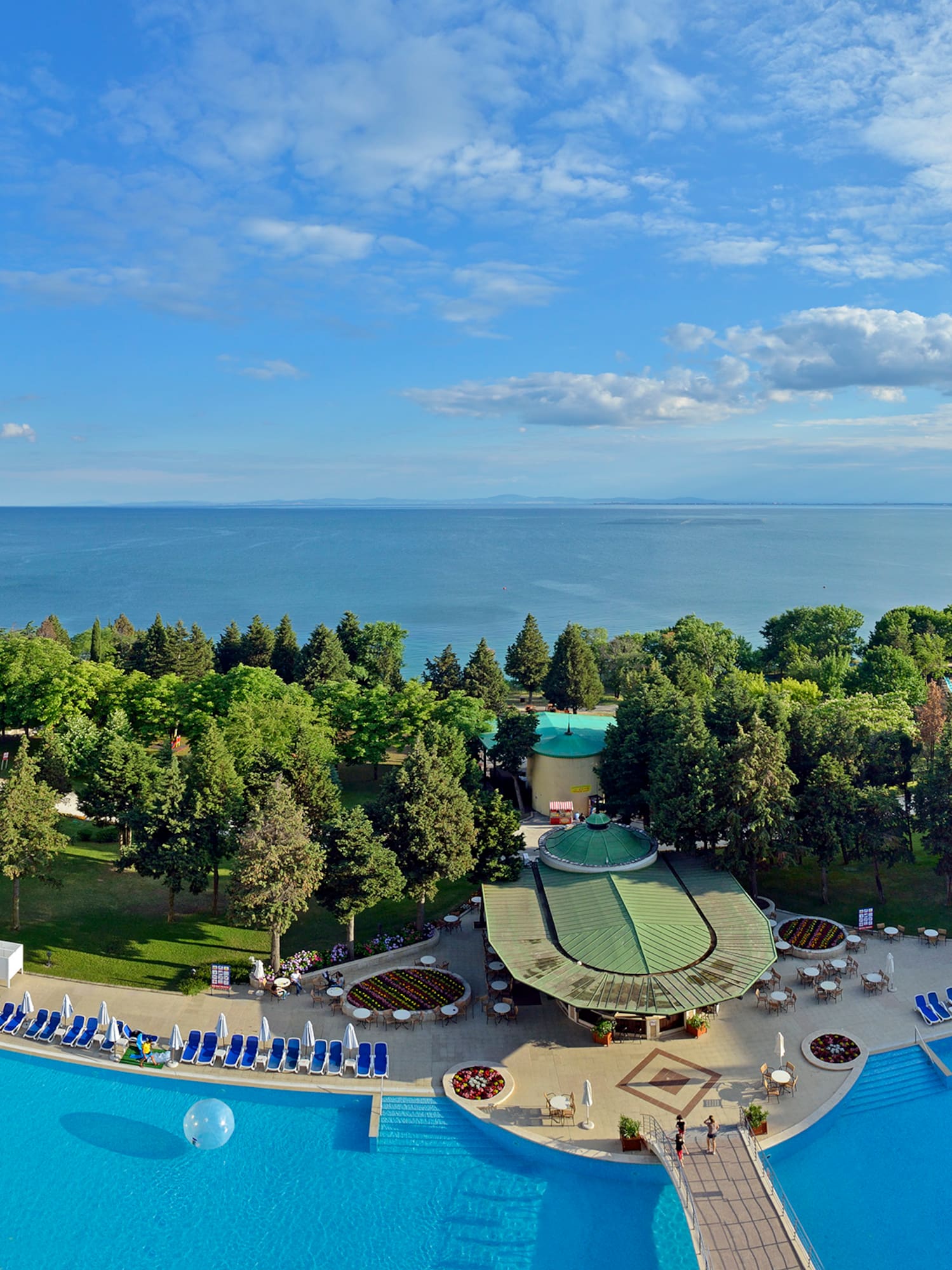 a pool with trees and a body of water