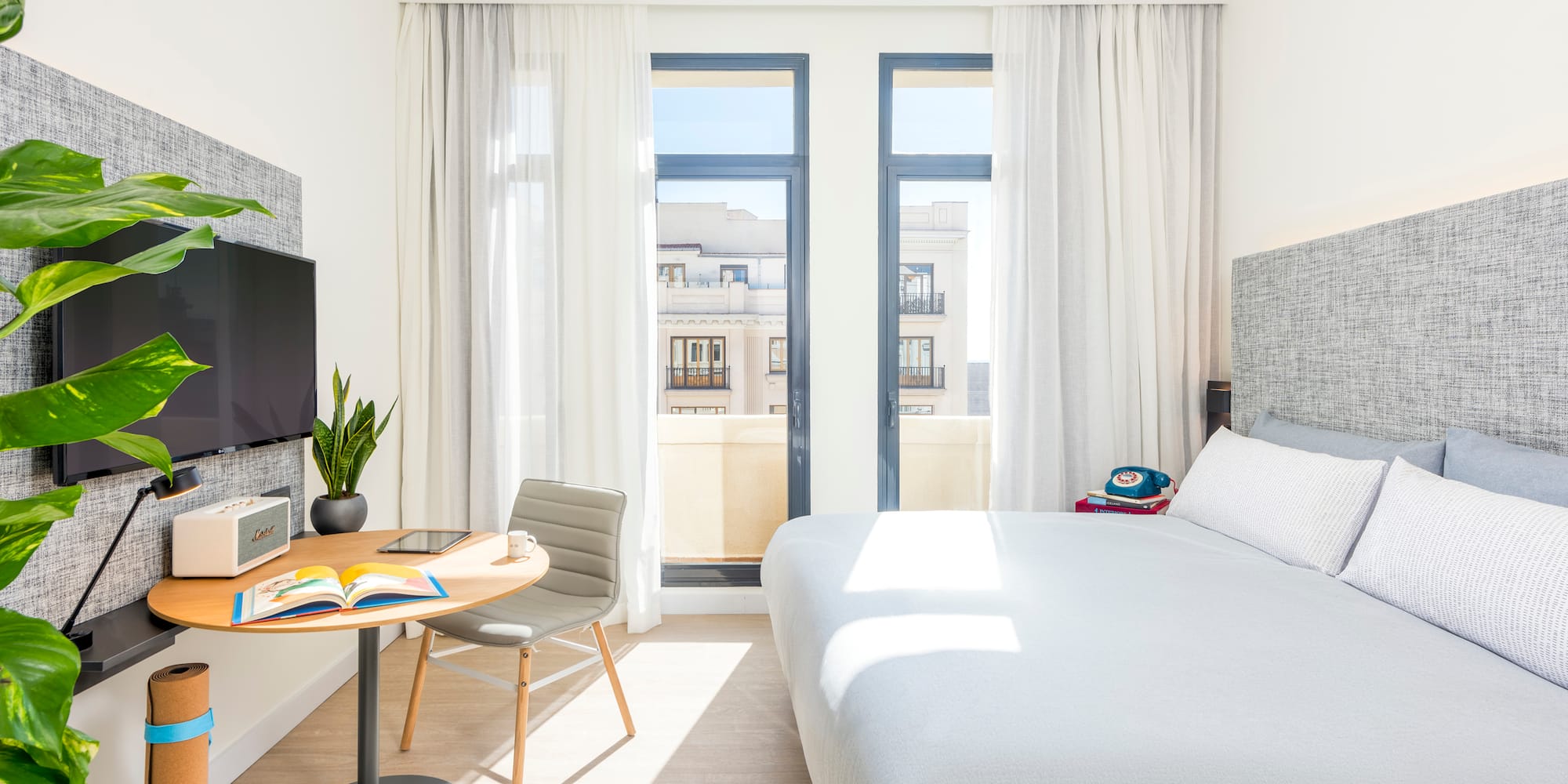 a bedroom with a bed and a table and a tv