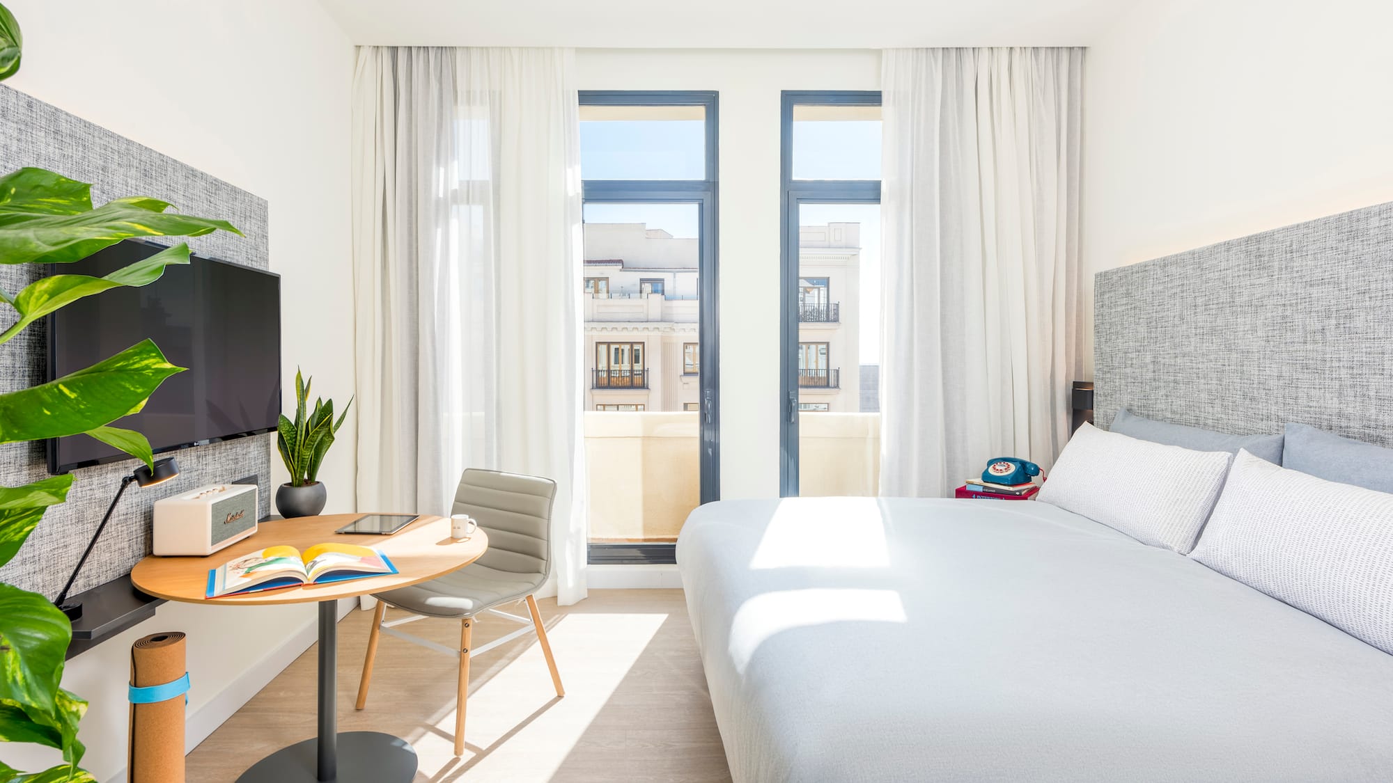 a bedroom with a bed and a table and a tv