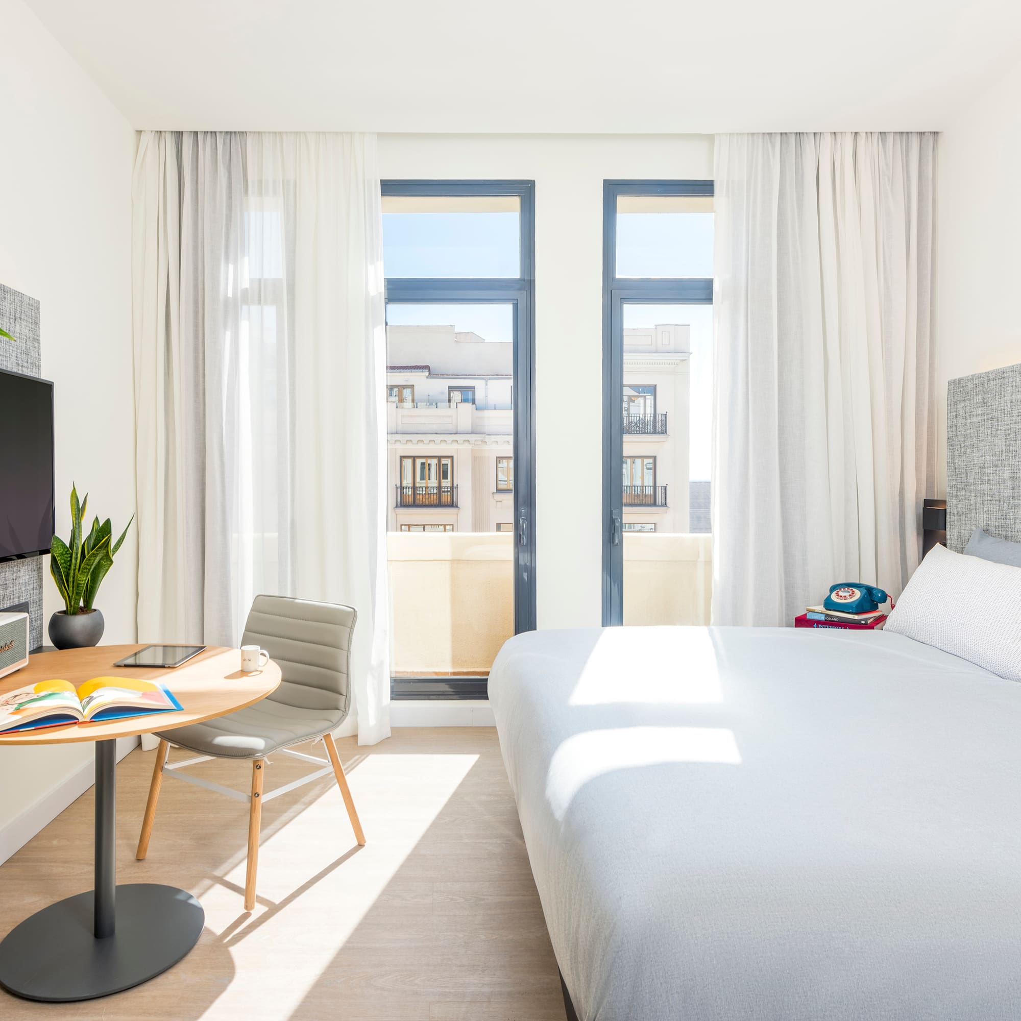 a bedroom with a bed and a table and a tv