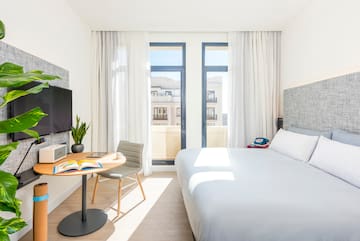 a bedroom with a bed and a table and a tv