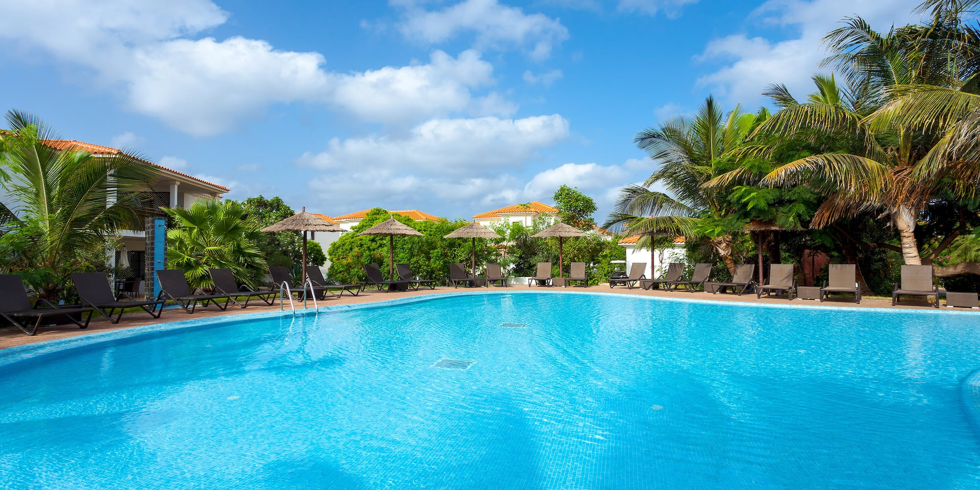 a pool with chairs and umbrellas