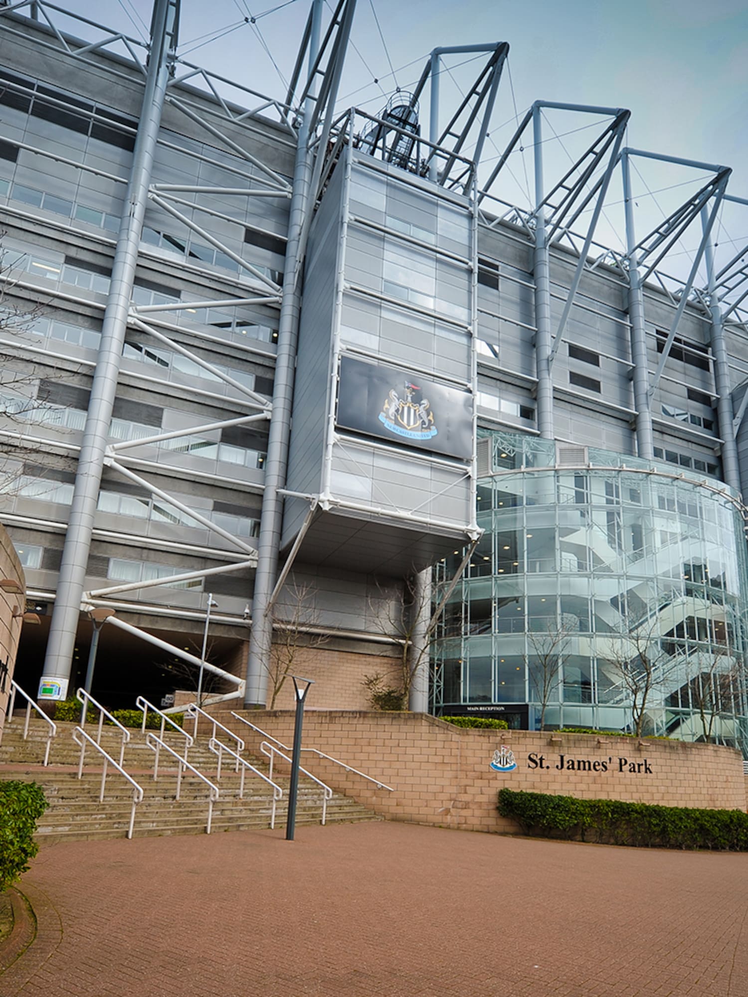 a large building with a glass wall and stairs