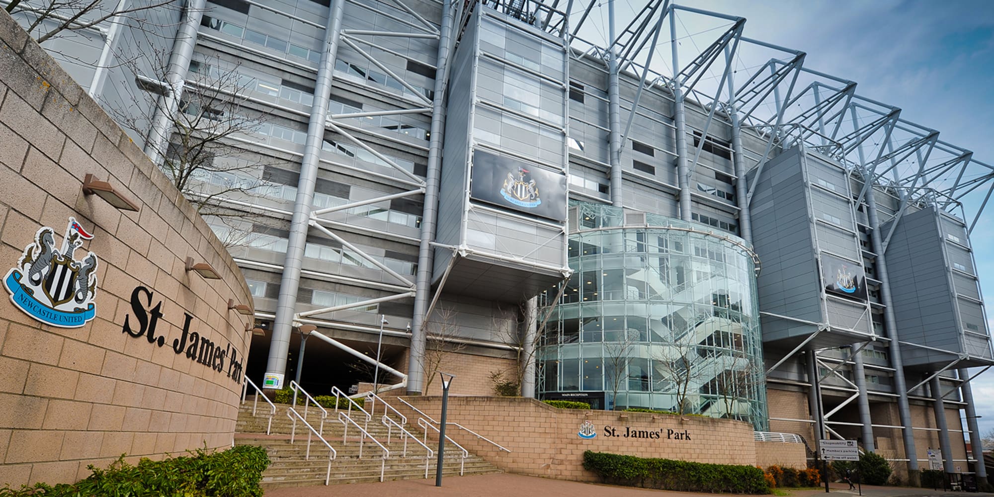 a large building with a glass wall and stairs