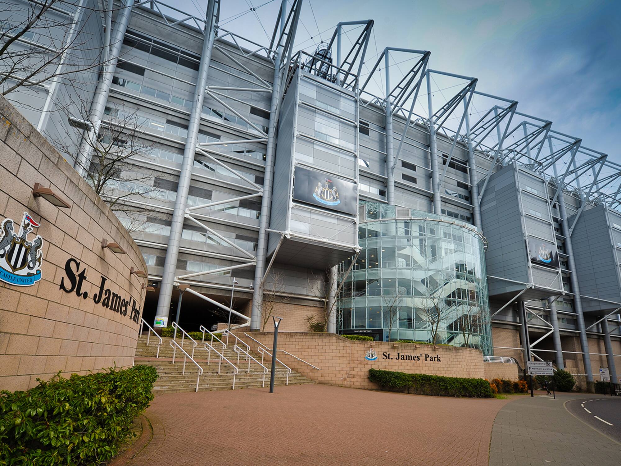 a large building with a glass wall and stairs