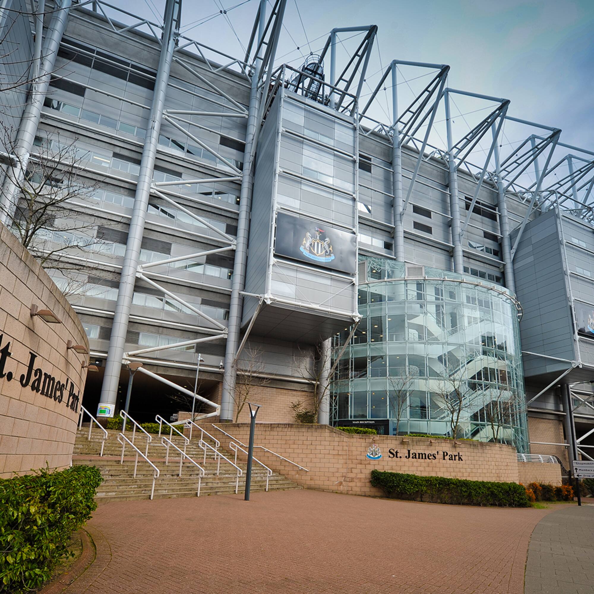 a large building with a glass wall and stairs