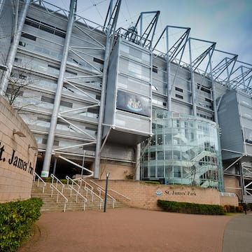 a large building with a glass wall and stairs
