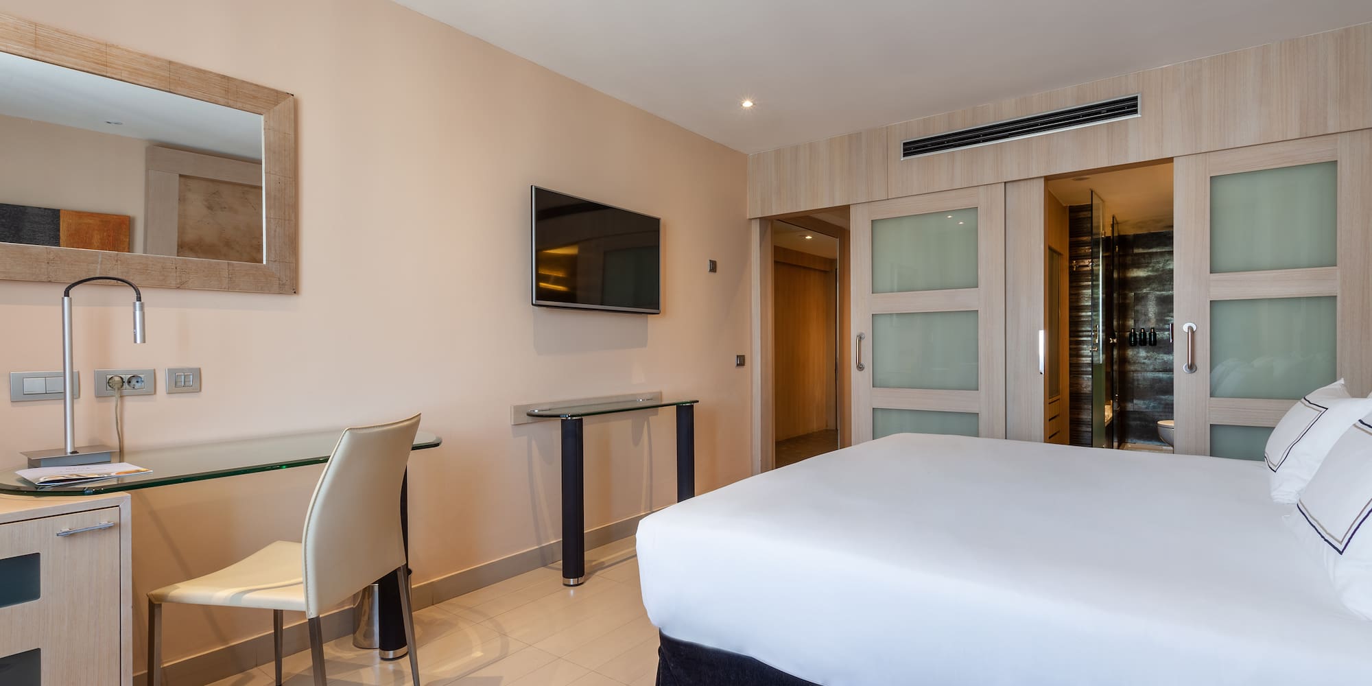 a room with a bed and a table and chairs